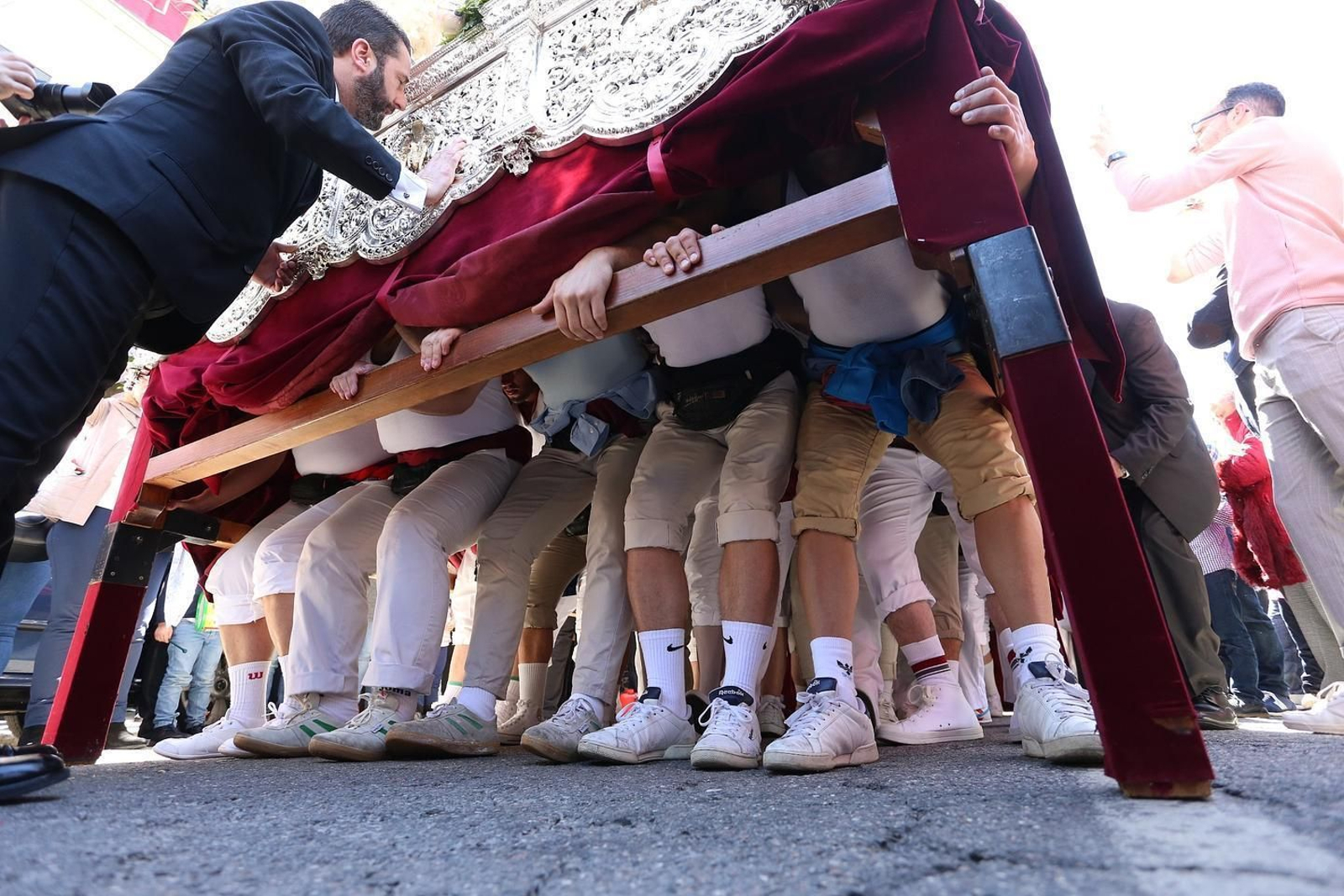 Costaleros de la Virgen de las Mercedes se preparan para una 'levantá'.