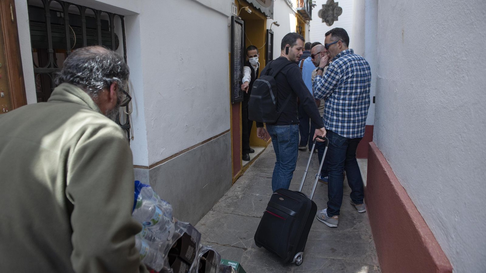 Varios turistas impiden la entrada de un pedido de bebidas en uno de los restaurantes de Santa Cruz.