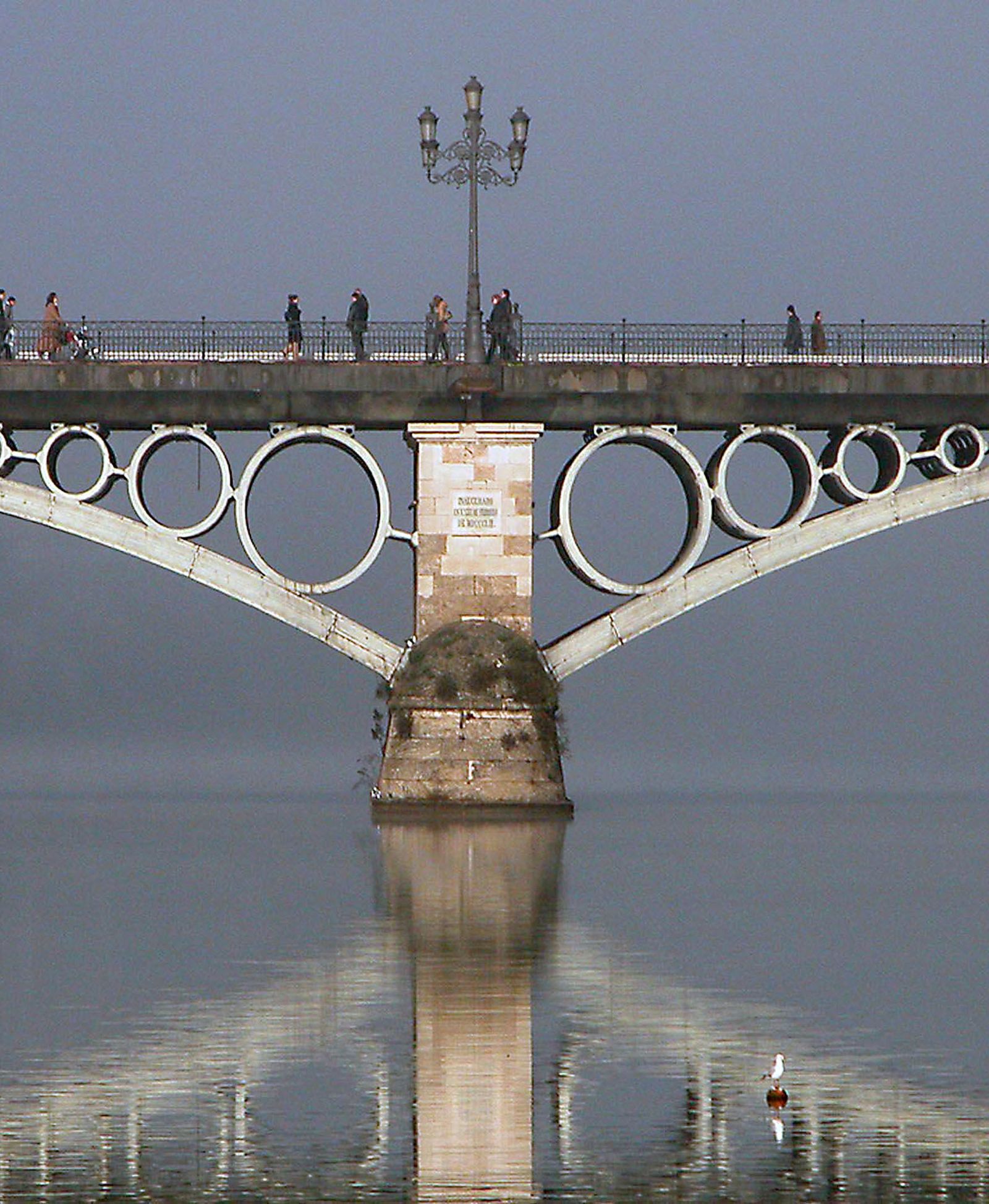 Vista del Puente de Triana, cordón umbilical de Sevilla y Triana, reflejándose en las aguas del viejo Betis.