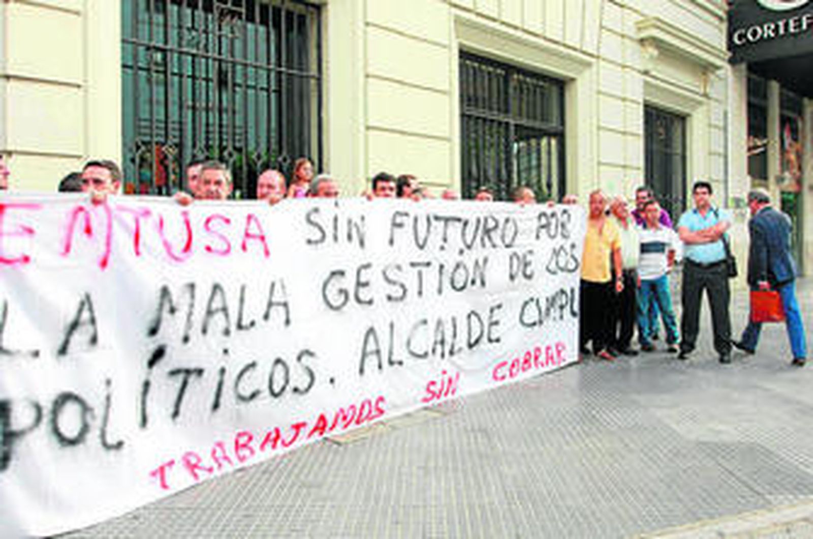 Francisco Moro, a la derecha, pasa ante los trabajadores concentrados a las puertas de Urbanismo.