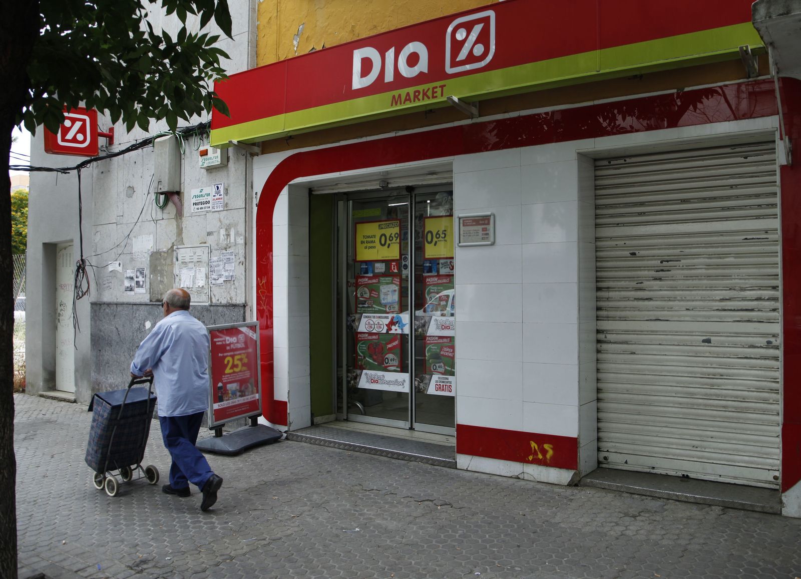 Un hombre pasa ante un supermercado Dia