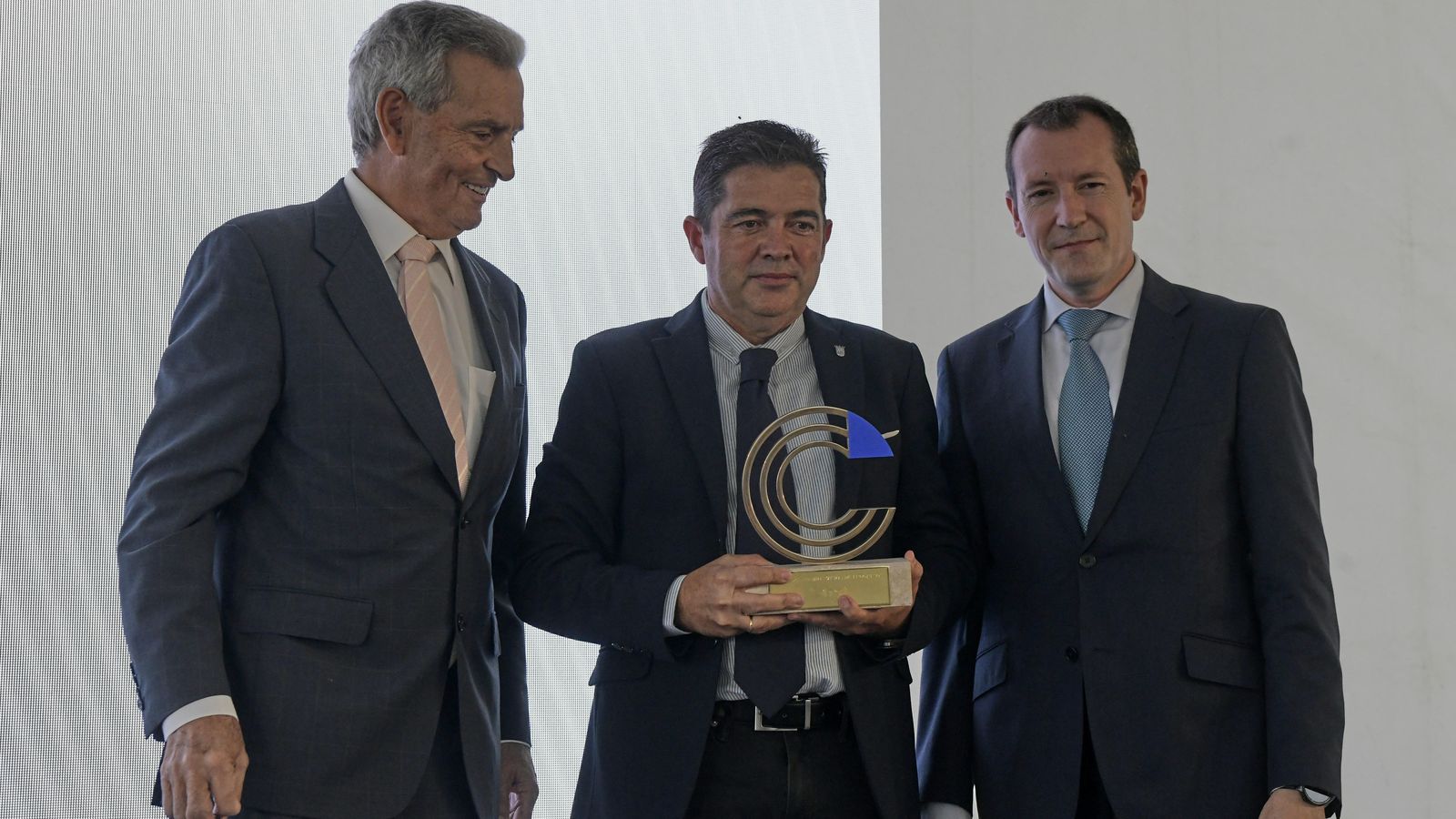 Carlos Infanzón y Angel García Lechuga junto al premiado.