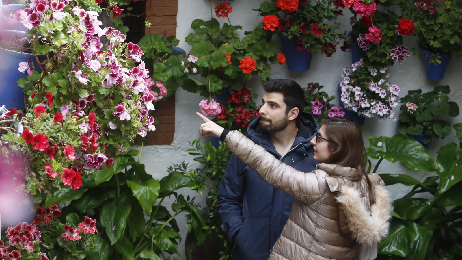 Dos visitantes se fijan en los detalles de los maceteros.