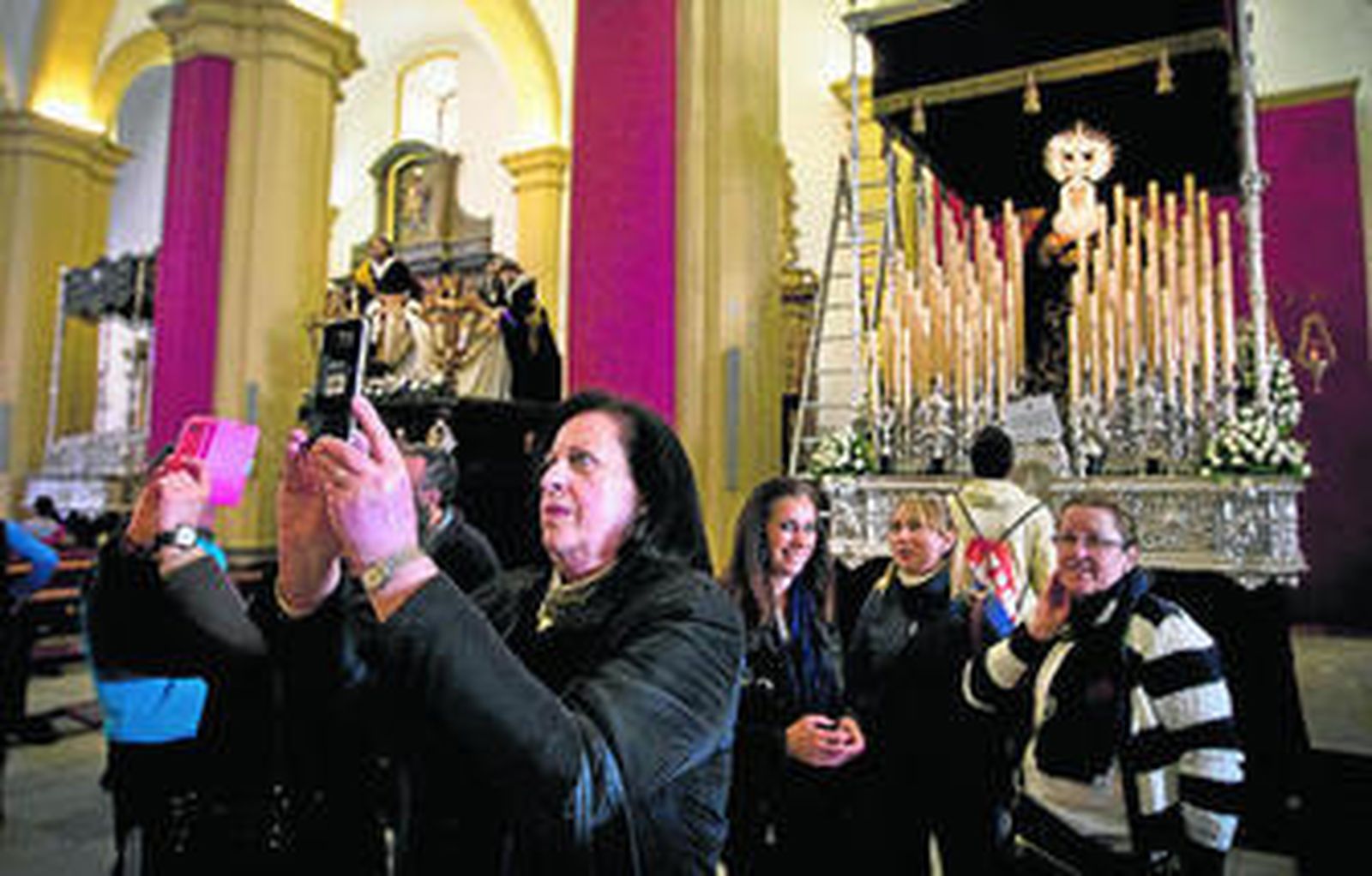 Isleños, en la Iglesia Mayor, haciendo fotos a los pasos de las distintas hermandades.