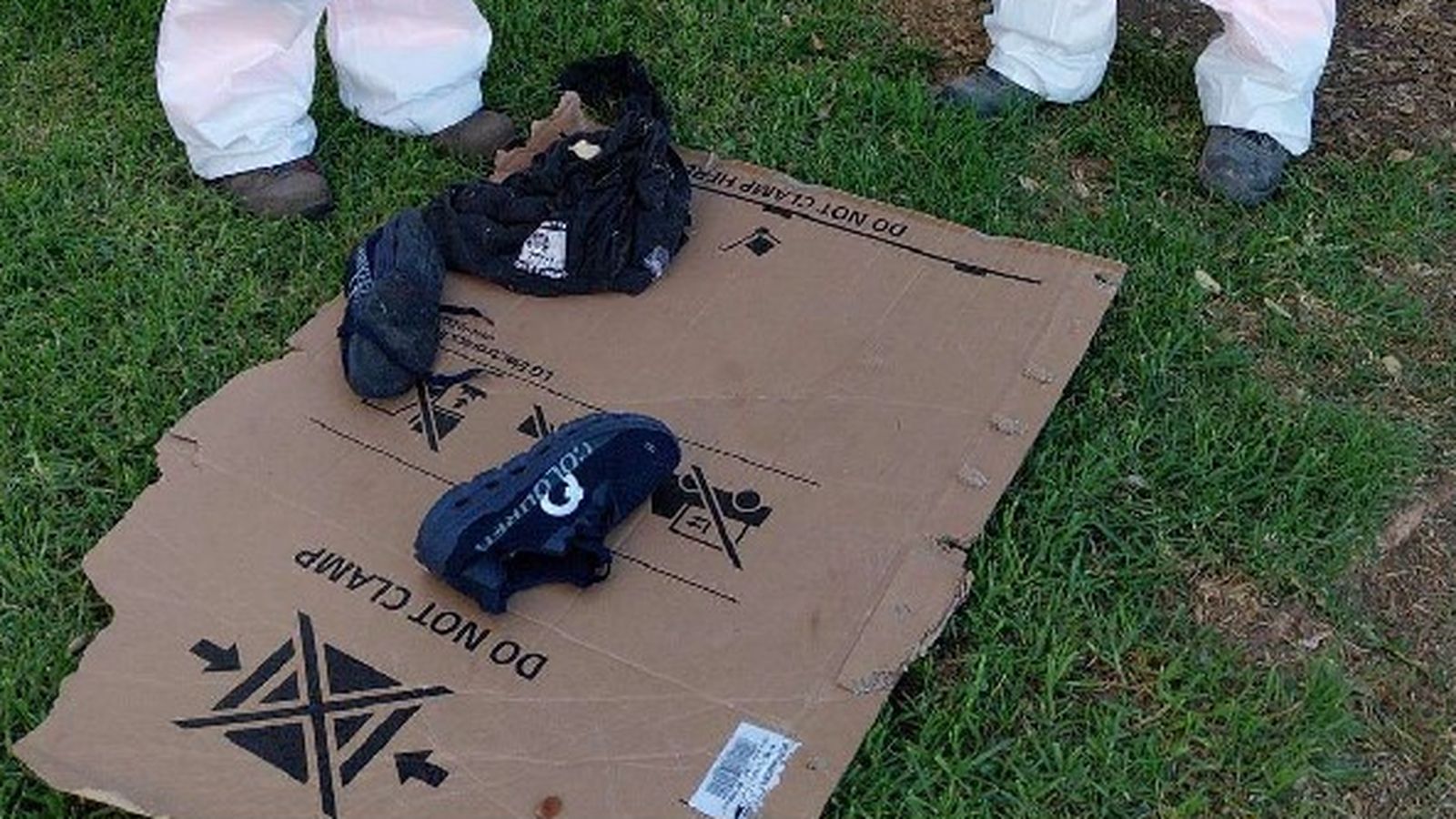 Par de zapatos y una prenda de ropa de una personas sin hogar en una zona verde.
