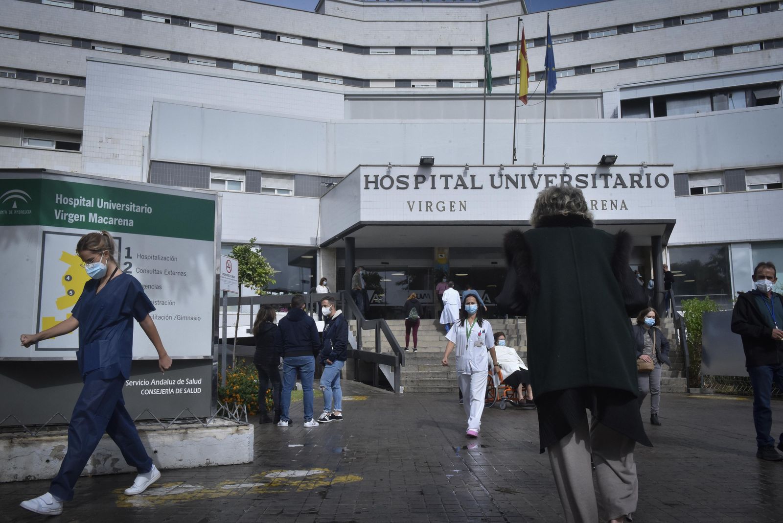 Sanitarios y pacientes en el entorno de la entrada principal del Hospital Virgen Macarena.