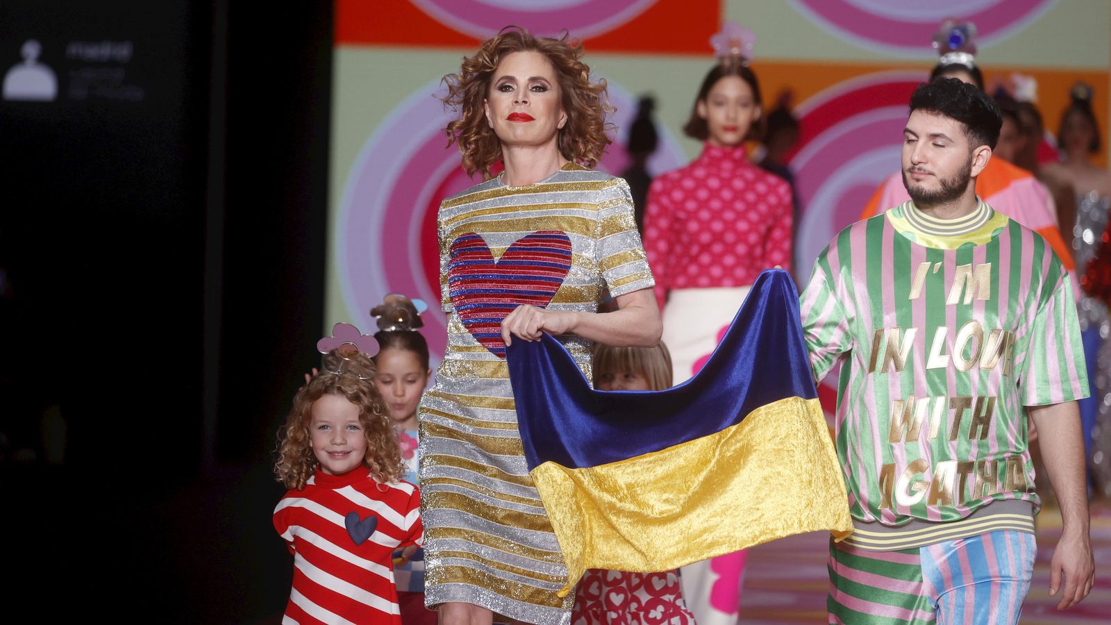 Ágatha Ruiz de la Prada y Omar Montes ondean la bandera de Ucrania al final del desfile de la diseñadora este jueves.