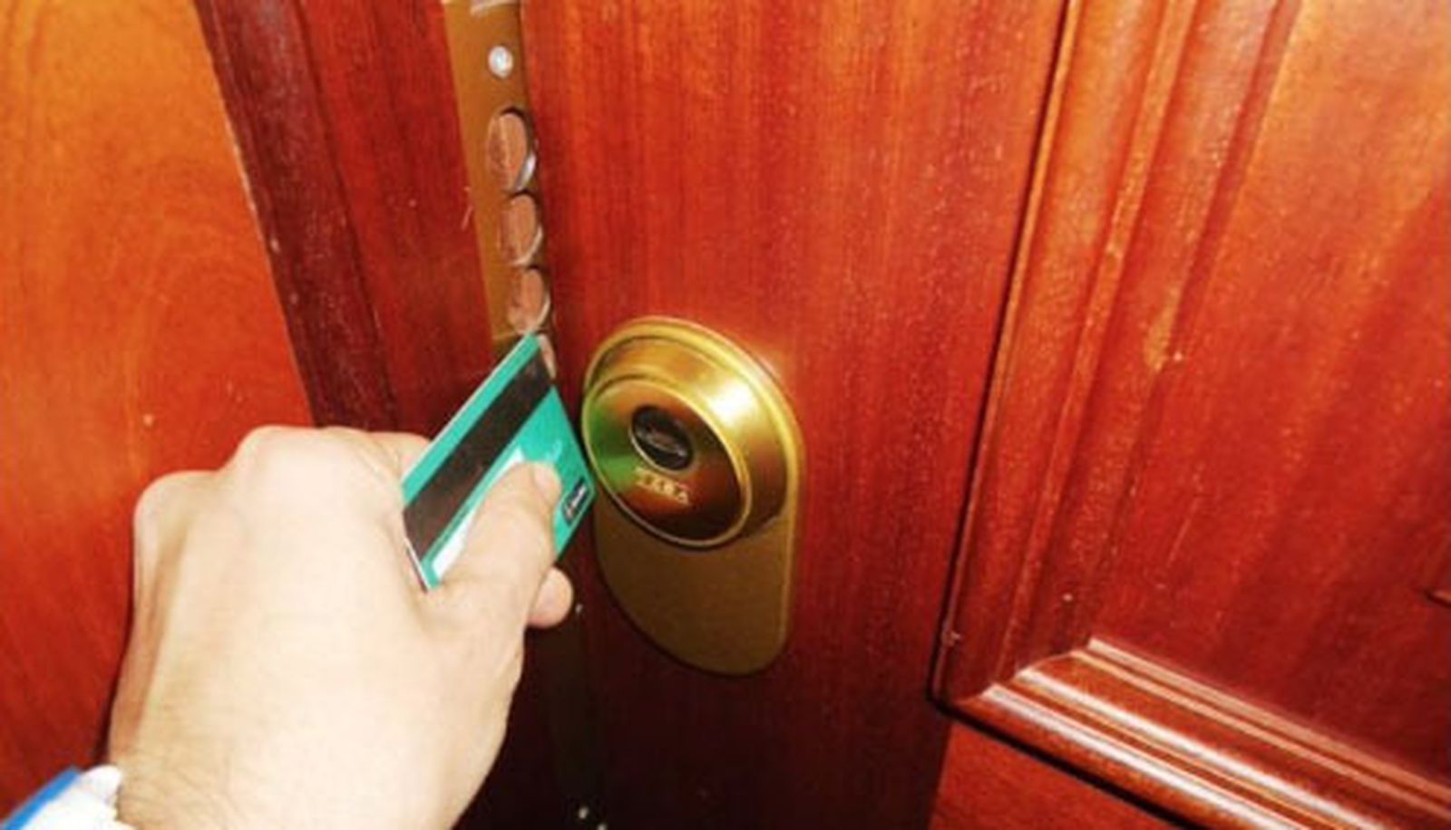 Una persona abre una puerta con una tarjeta de crédito