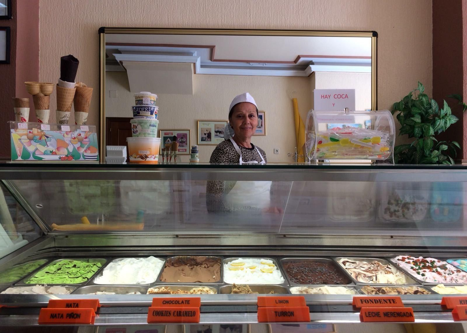 Isabel Grao tras la colorida vitrina de la heladería La Perla, en el Paseo de los Reyes de Isla Cristina.