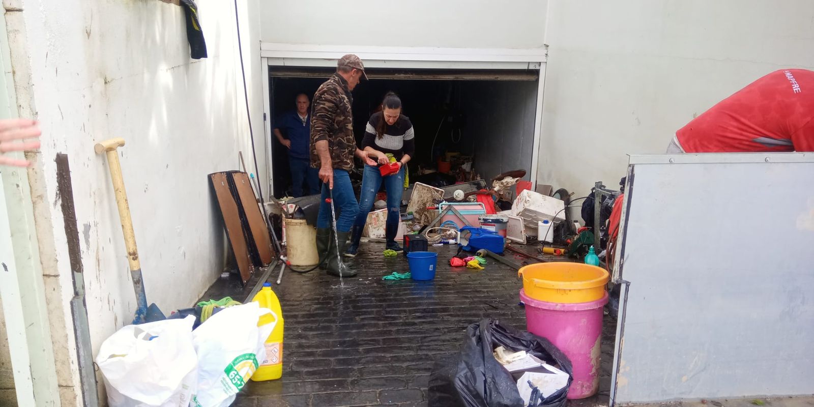 Vecinos realizando labores de limpieza en una vivienda de la calle Gaucín.