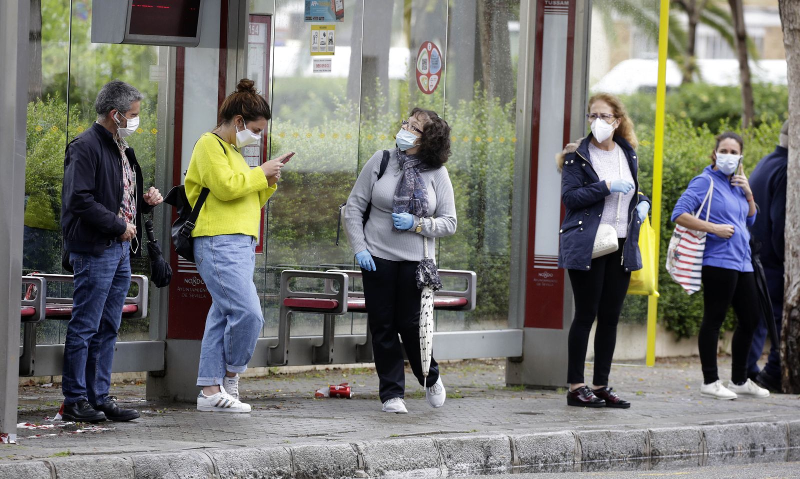 Varias personas aguardan la llegada del autobús manteniendo las distancias de seguridad.