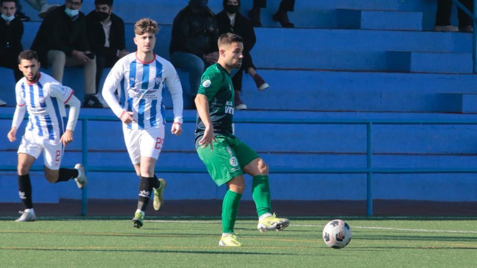 Adri se dispone a golpear con el interior ante Manu Torres y Andrés.