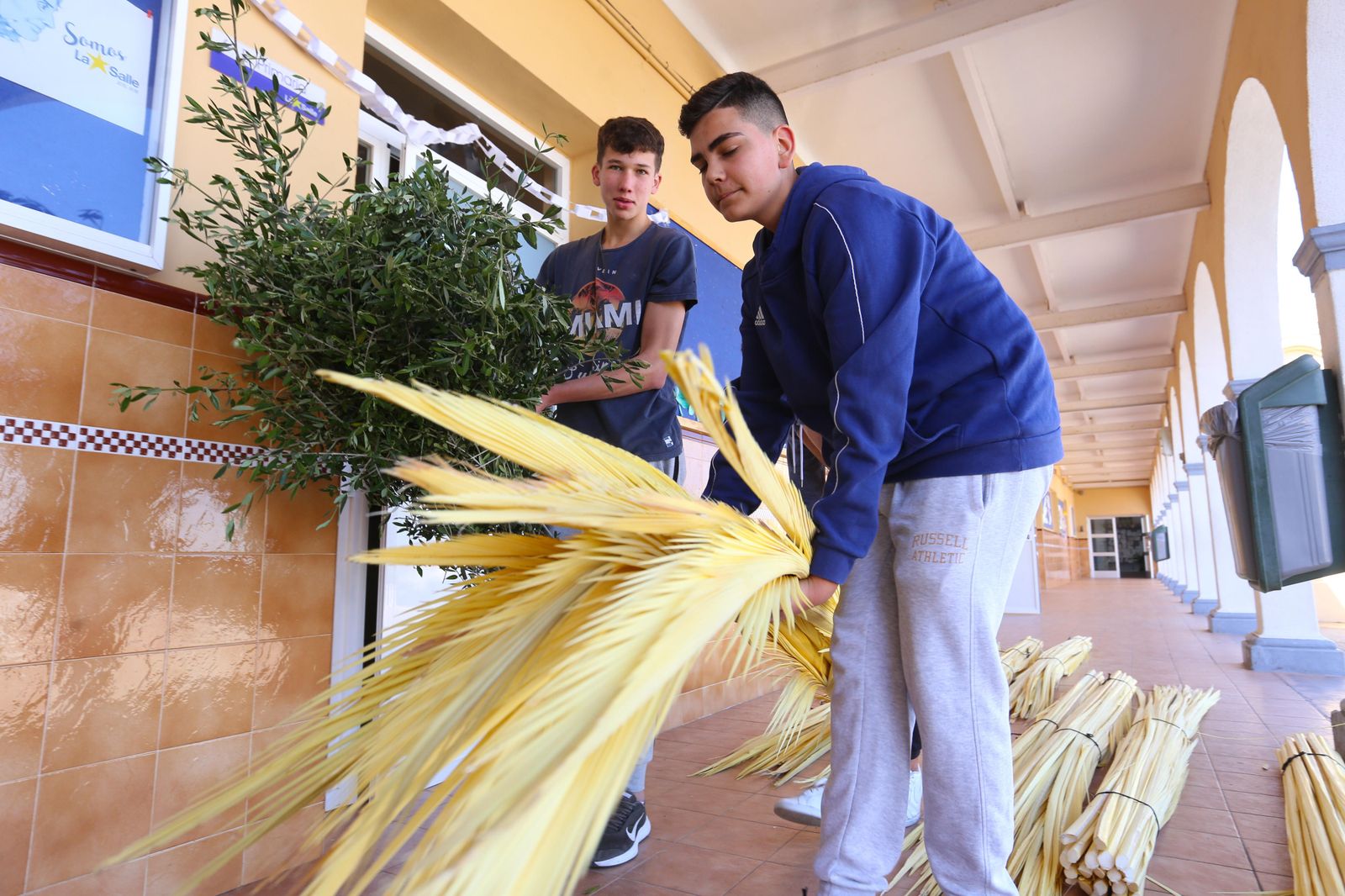 Dos jóvenes preparan las palmas para la procesión de La Borriquita, en una imagen del pasado año.