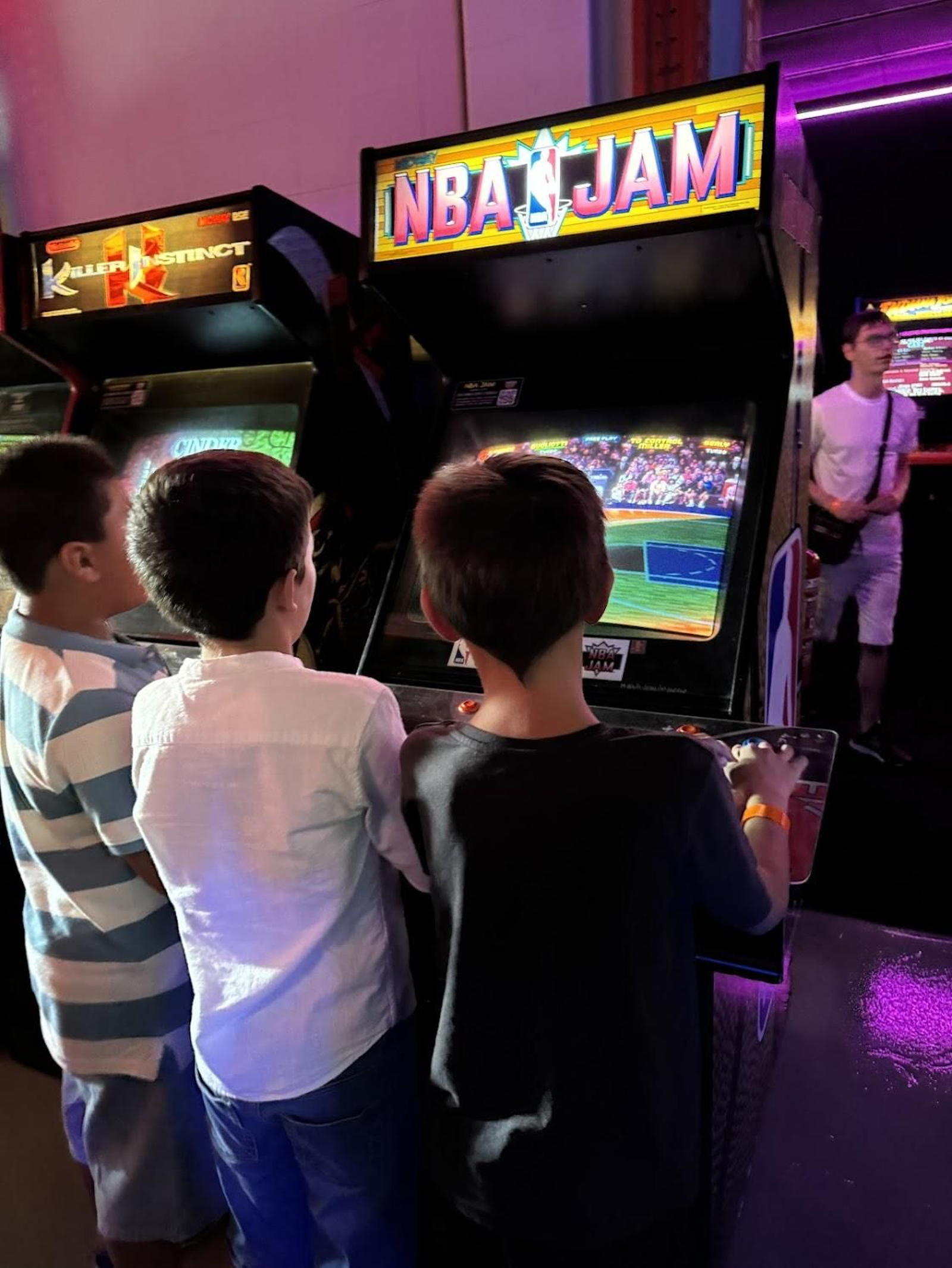Varios niños juegan en una de las máquinas recreativas de Arcade Planet Sevilla.