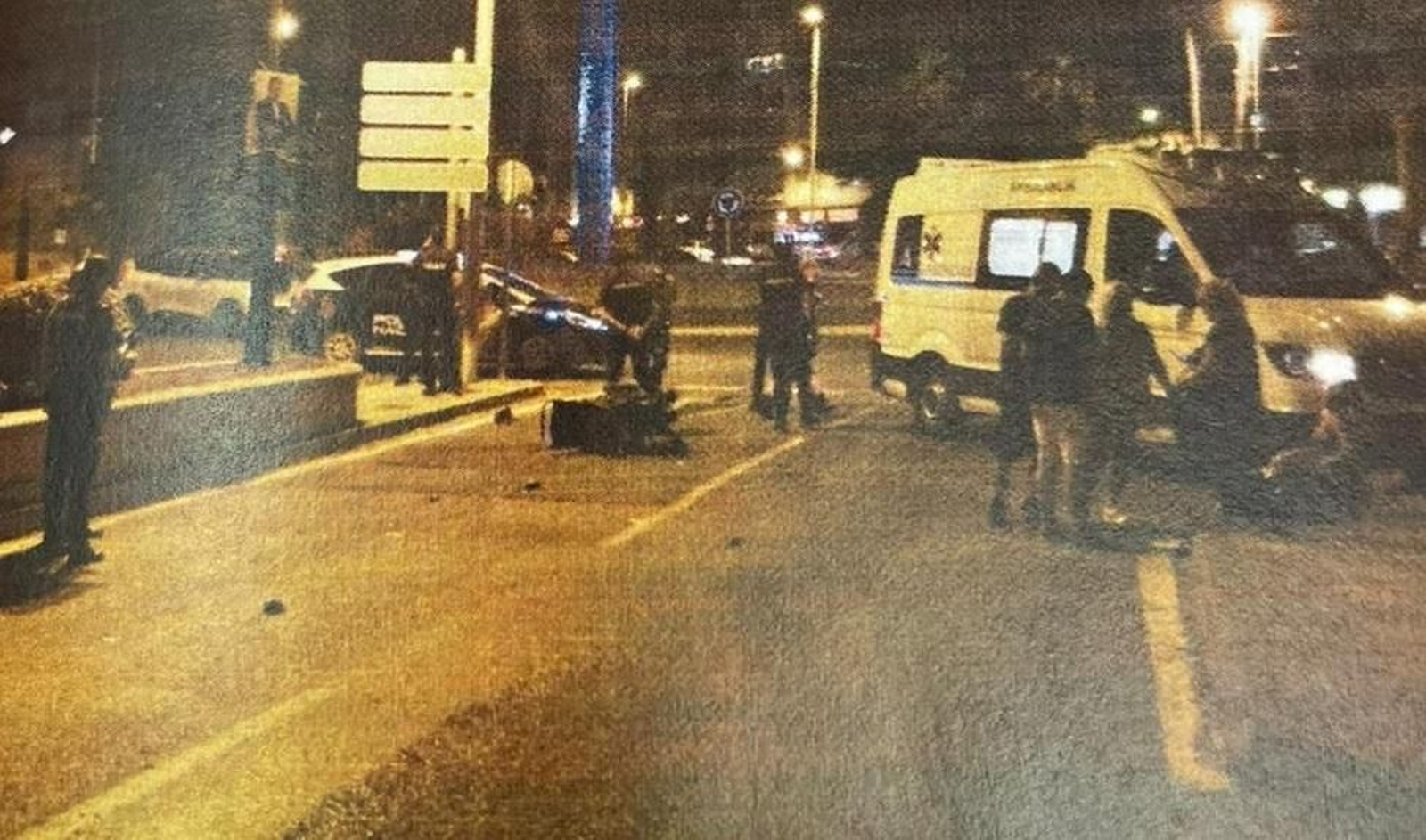 La silla de ruedas en la que iba la víctima, rodeada de agentes y varios testigos.