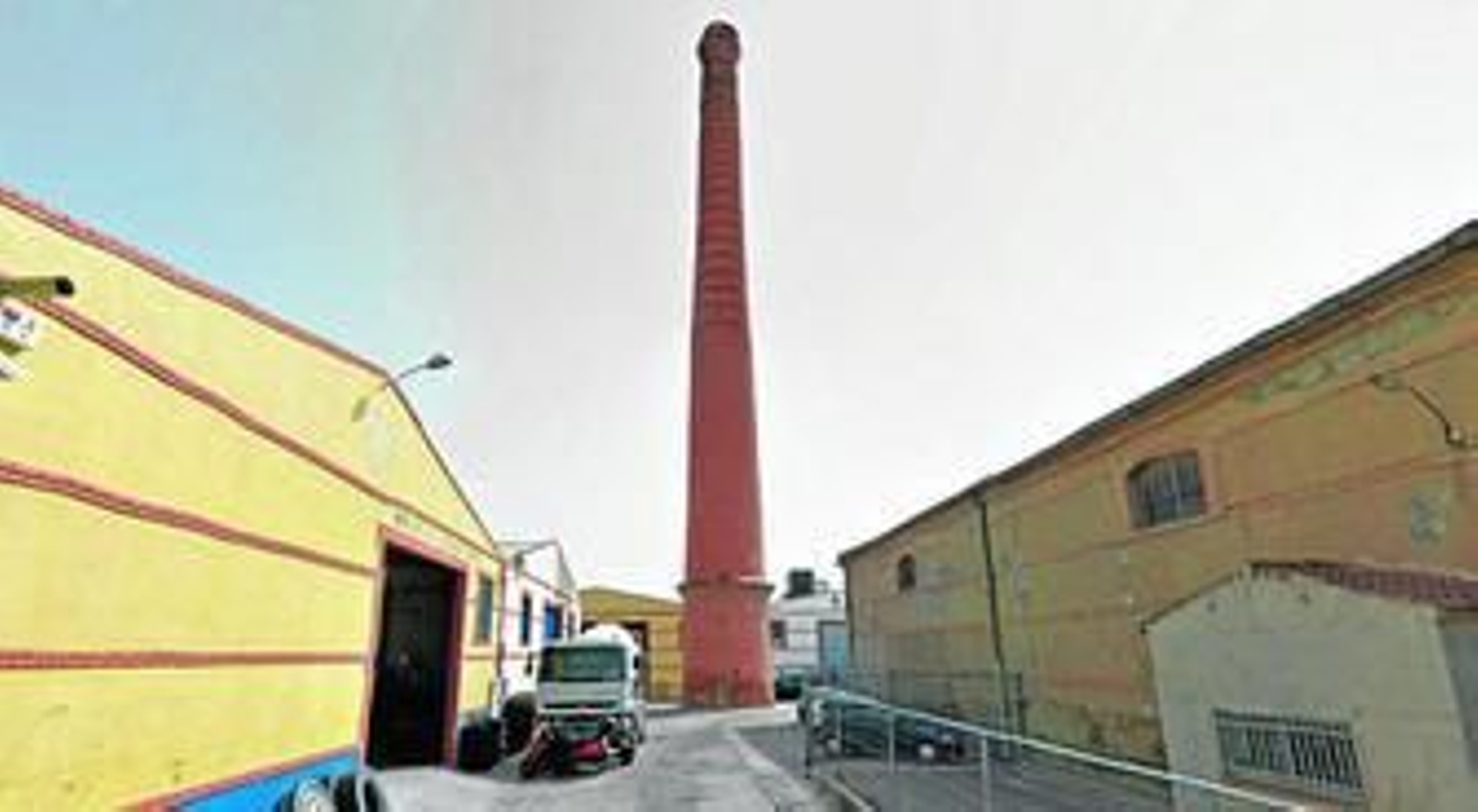 Una de las calles del polígono con la chimenea en el centro.