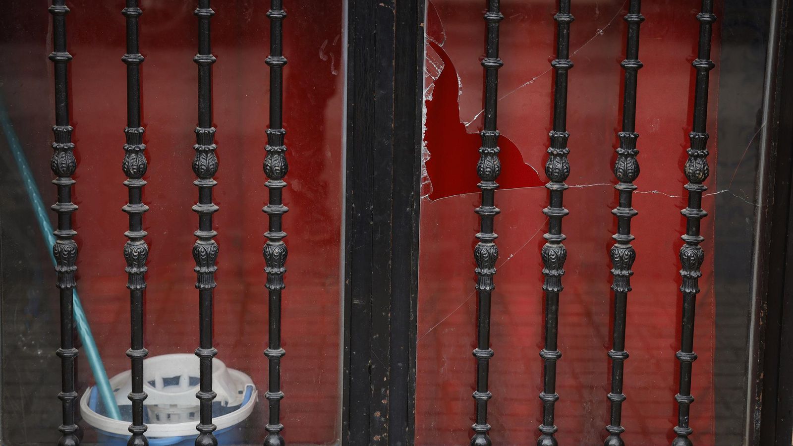 Cristal roto en la puerta de la casa tiroteada.