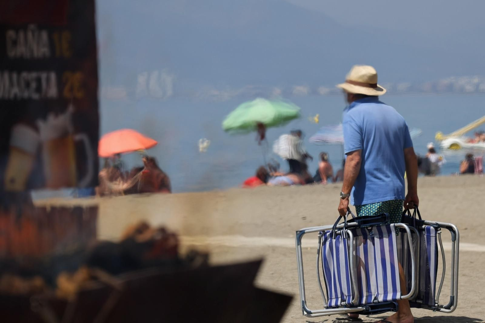 Un hombre camina hacia la playa en Málaga, en un día de terral abrasador.
