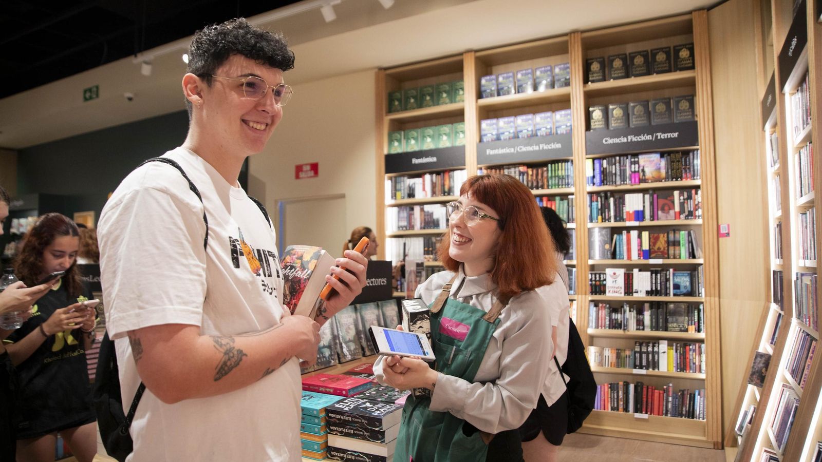 Carmen asesorando a un lector sobre un libro.