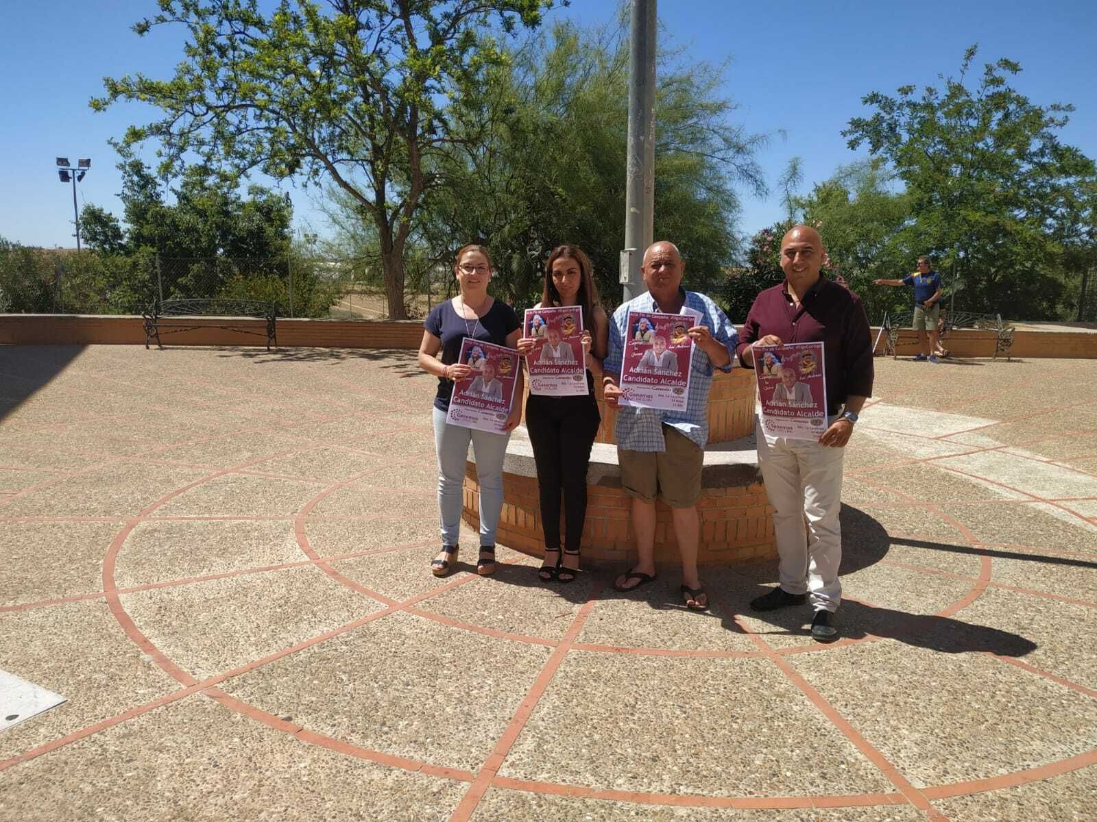 Miembros de la candidatura de Ganemos con el cartel del evento.
