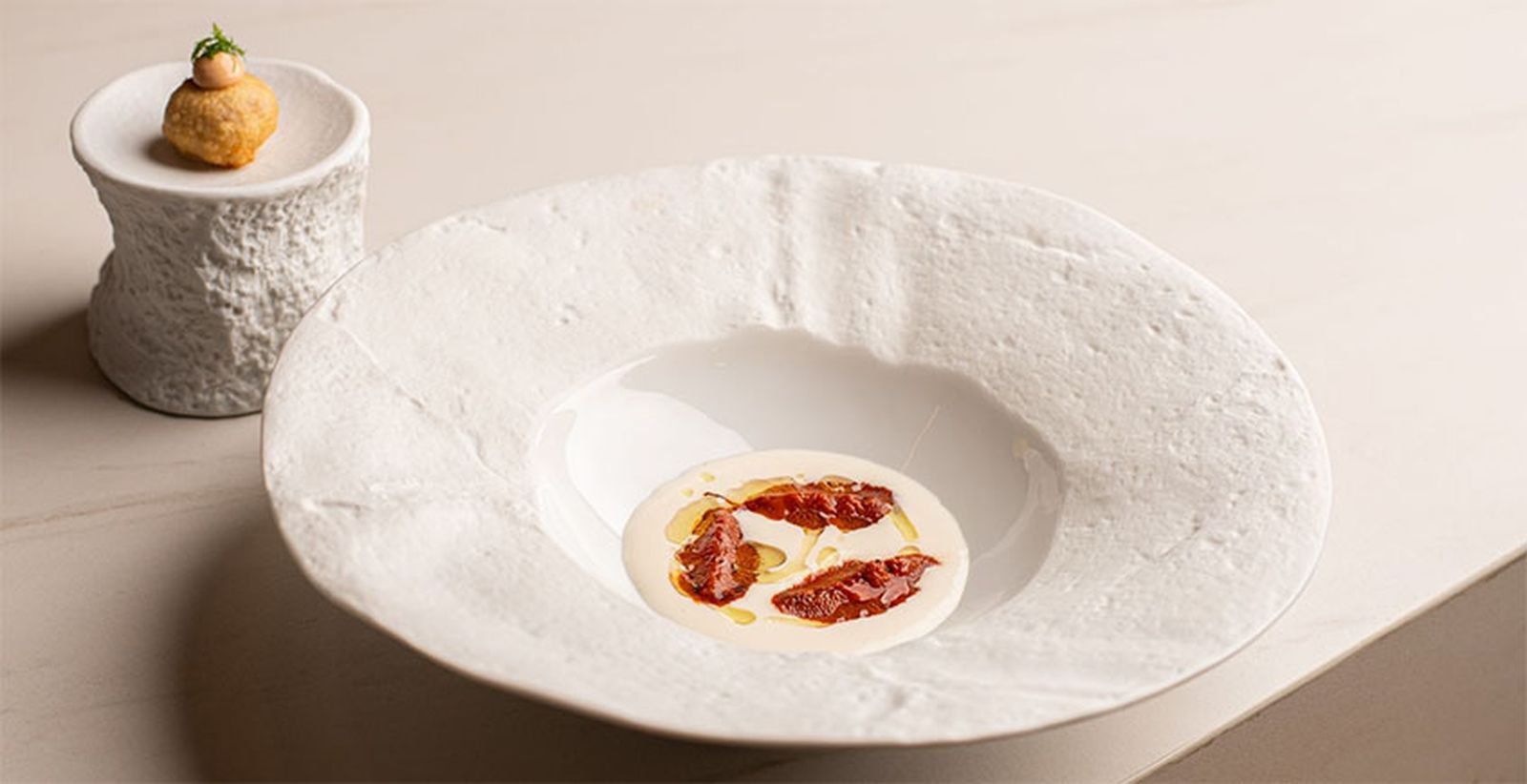 Puchero con erizos y un buñuelo con la pringá