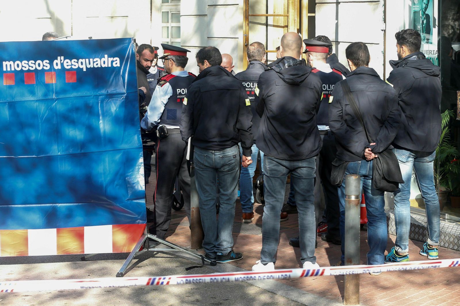Varios agentes y sanitarios trasladan el cadáver de la joven asesinada en un bar de Barcelona.