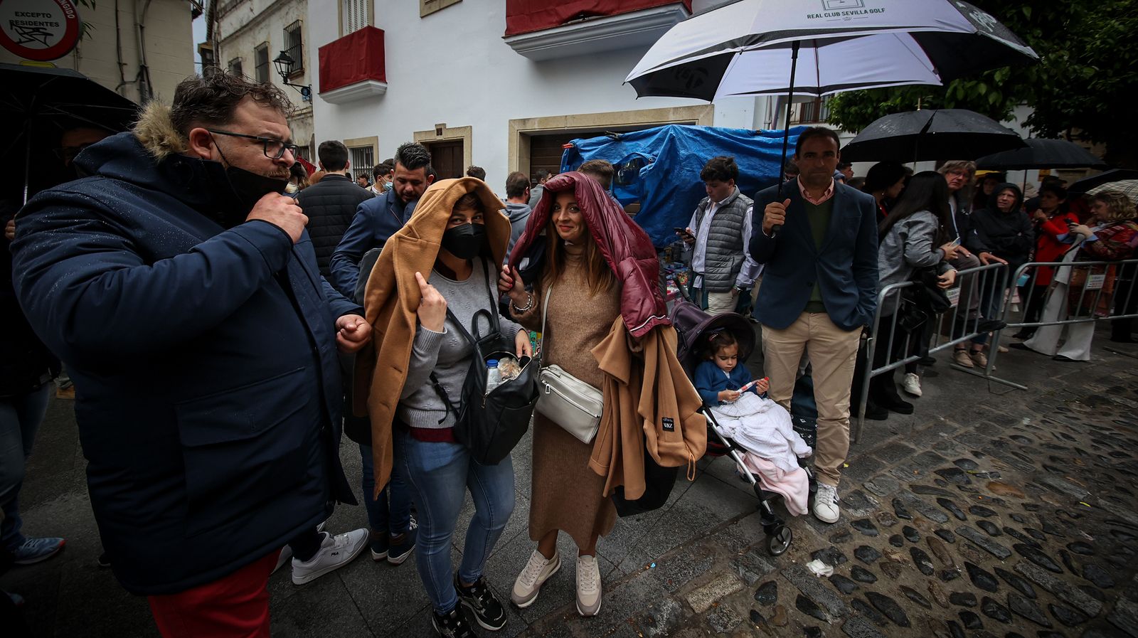 Público en pleno aguacero esperando el paso de una procesión.
