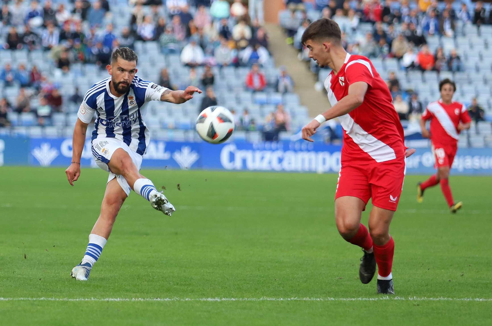 Adri Arjona golpea la pelota con la oposición de Kike Salas. Adri Arjona golpea la pelota con la oposición de Kike Salas.