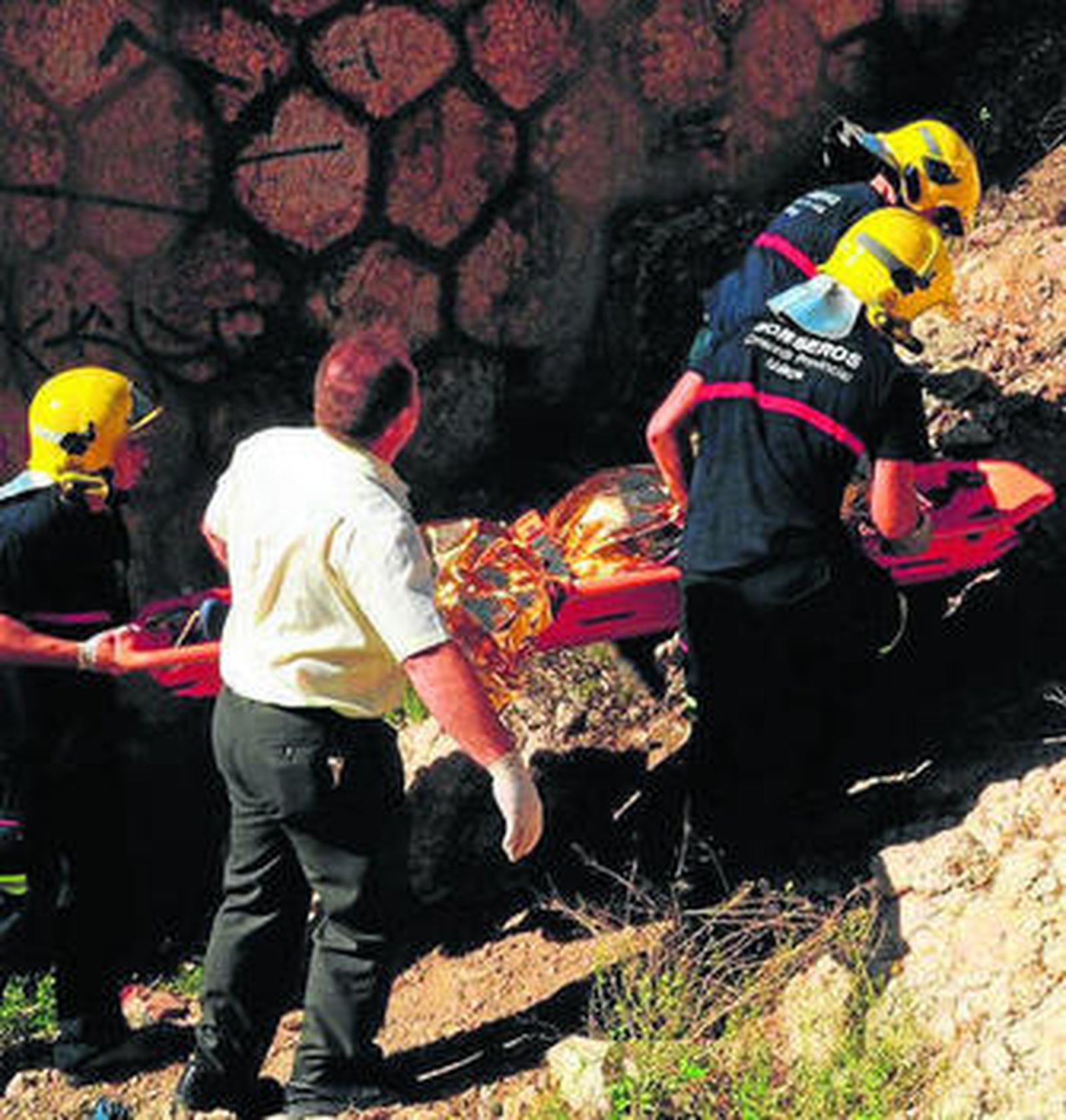 Miembros del Consorcio Provincial de Bomberos rescatan el cadáver.