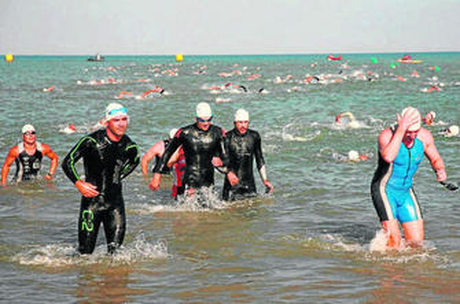 Participantes salen del agua en la playa de Punta Candor tras el tramo de natación.