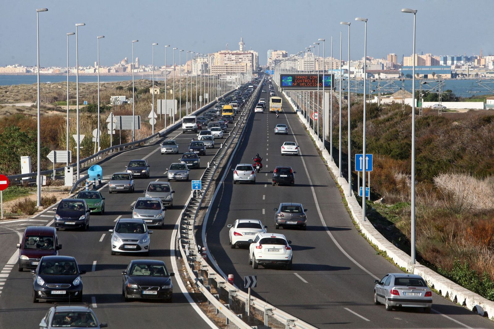 El tramo de la CA-33 en dirección a Cádiz, con la playa y las dunas de la playa de Cortadura, a la izquierda, visto desde el puente de Torregorda.