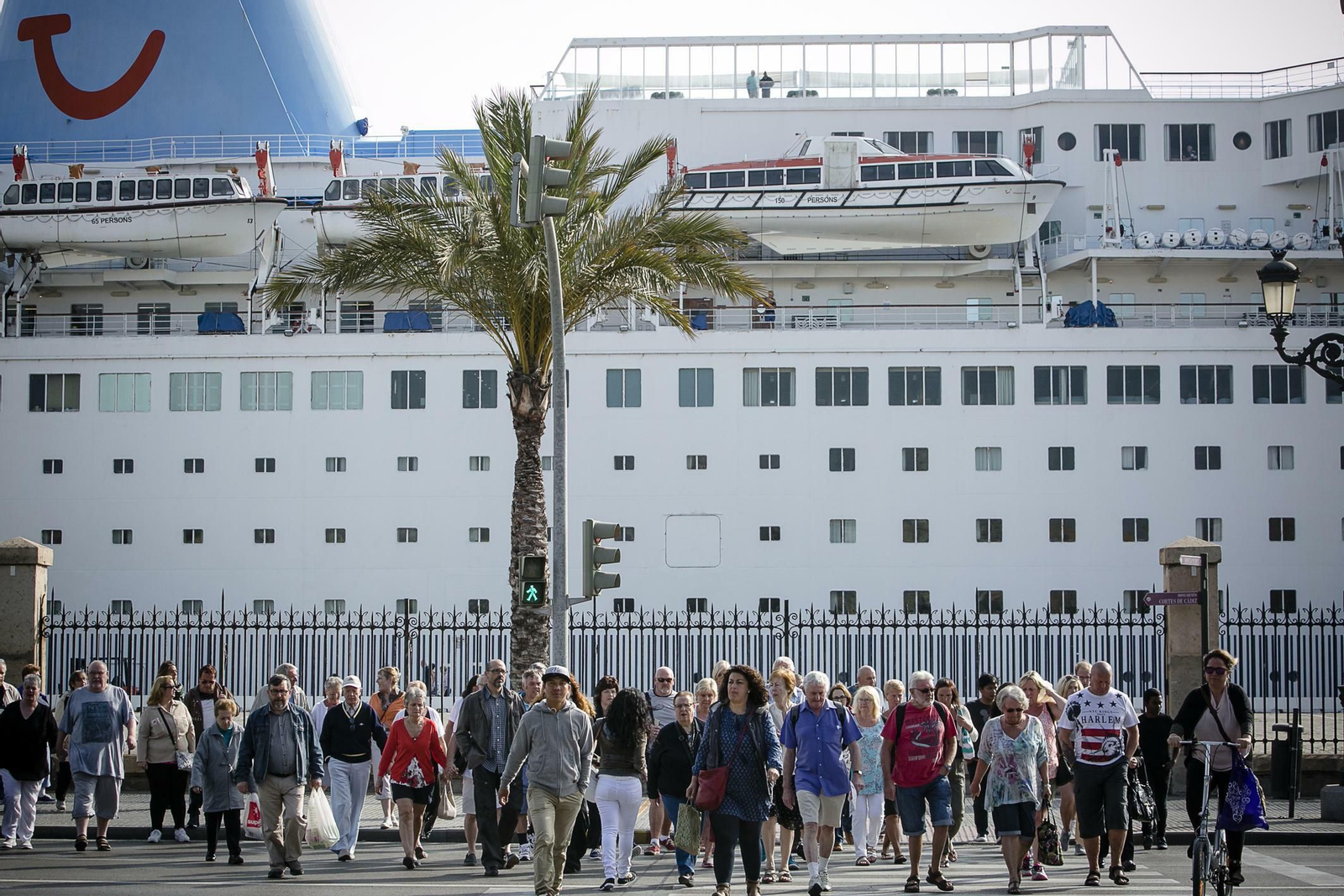 Turistas cruzan un paso de peatones de la Avenida del Puerto.