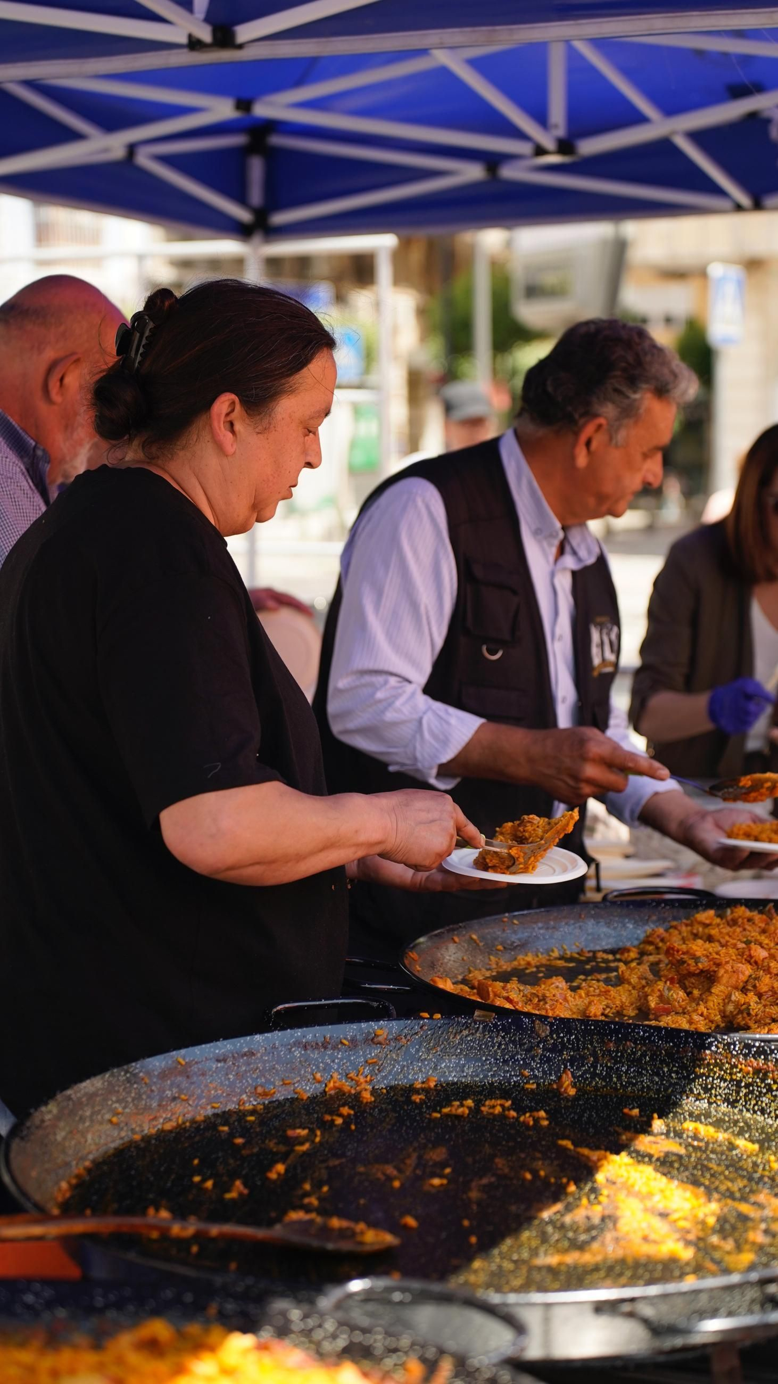 Muchas personas se reunen en la Plaza Alta, bailando y comiendo paella junto a la Feria de los Parques Naturales de Cádiz