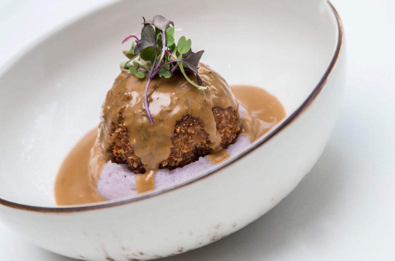 Bomba de solomillo de cerdo ibérico rellena de queso de cabra y cebolla caramelizada con salsa de amaretto y soja.