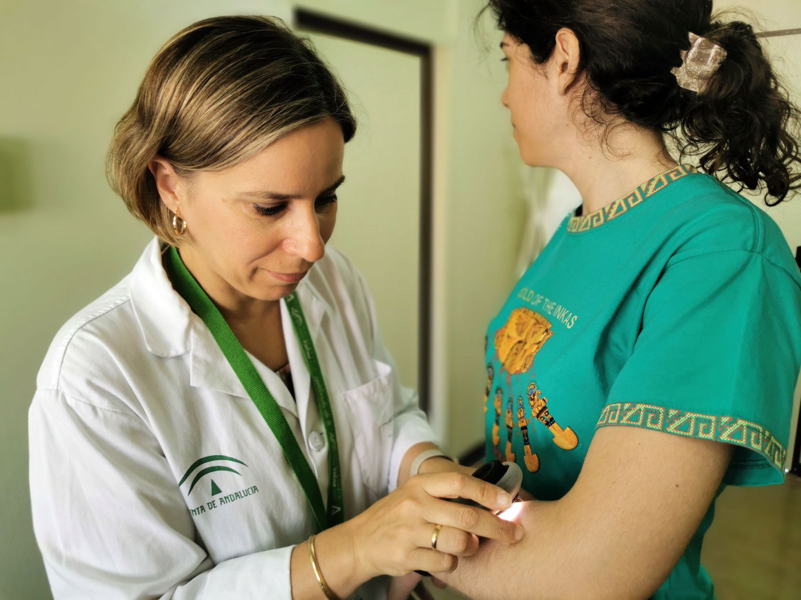 La doctora María coronel revisando a una paciente con el dermatoscopio.