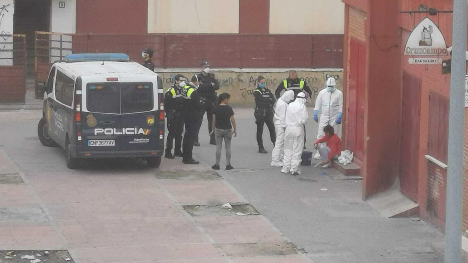 La víctima, sentada en un bordillo, es atendida por los servicios sanitarios.