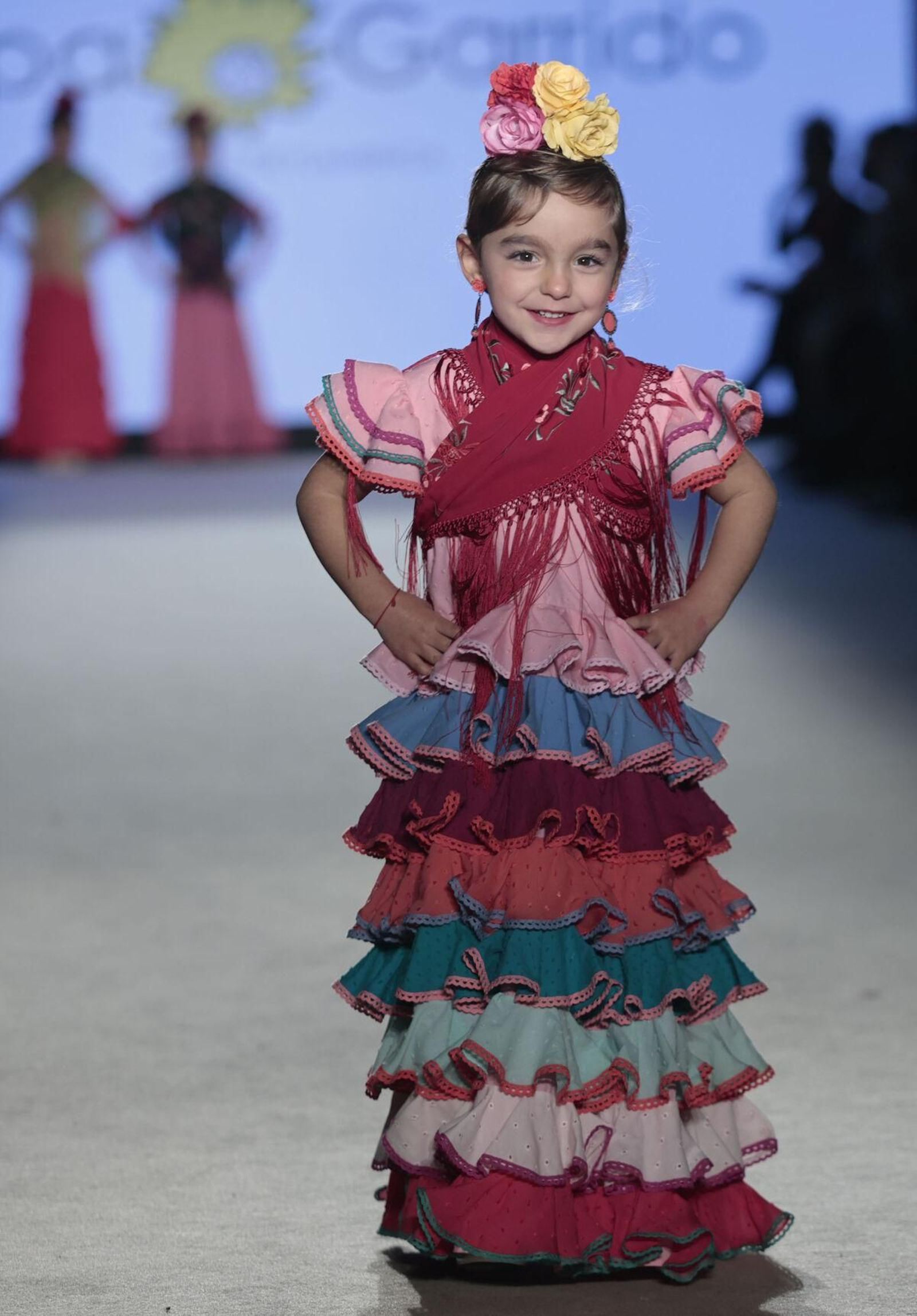 Traje de flamenca infantil con muchos volantes y el mantoncillo cruzado.