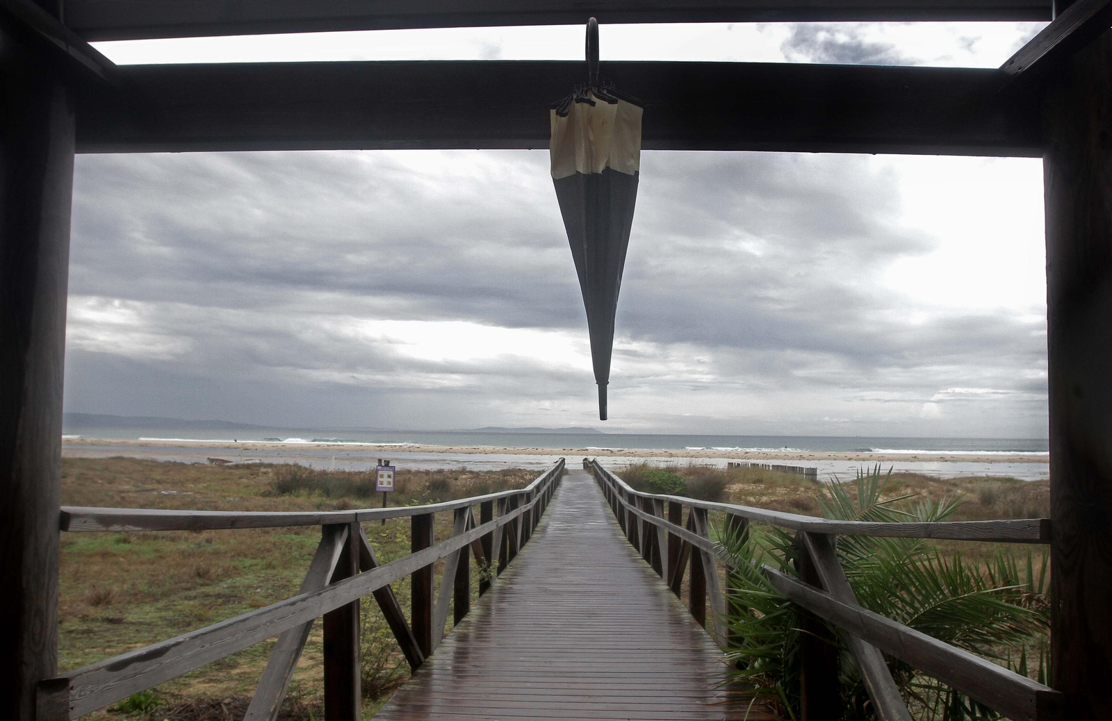 Un paraguas colgado en una de las pasarelas de la playa de Tarifa.