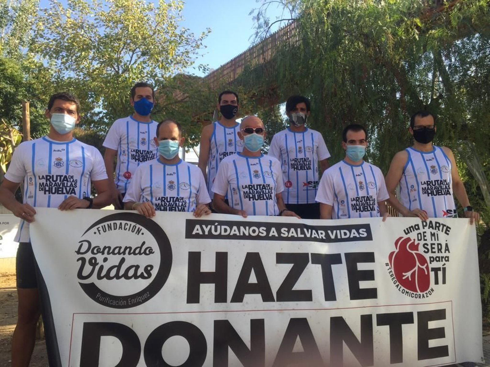 Atletas integrantes de la acción solidaria posan con el cartel en favor de la donación de órganos.
