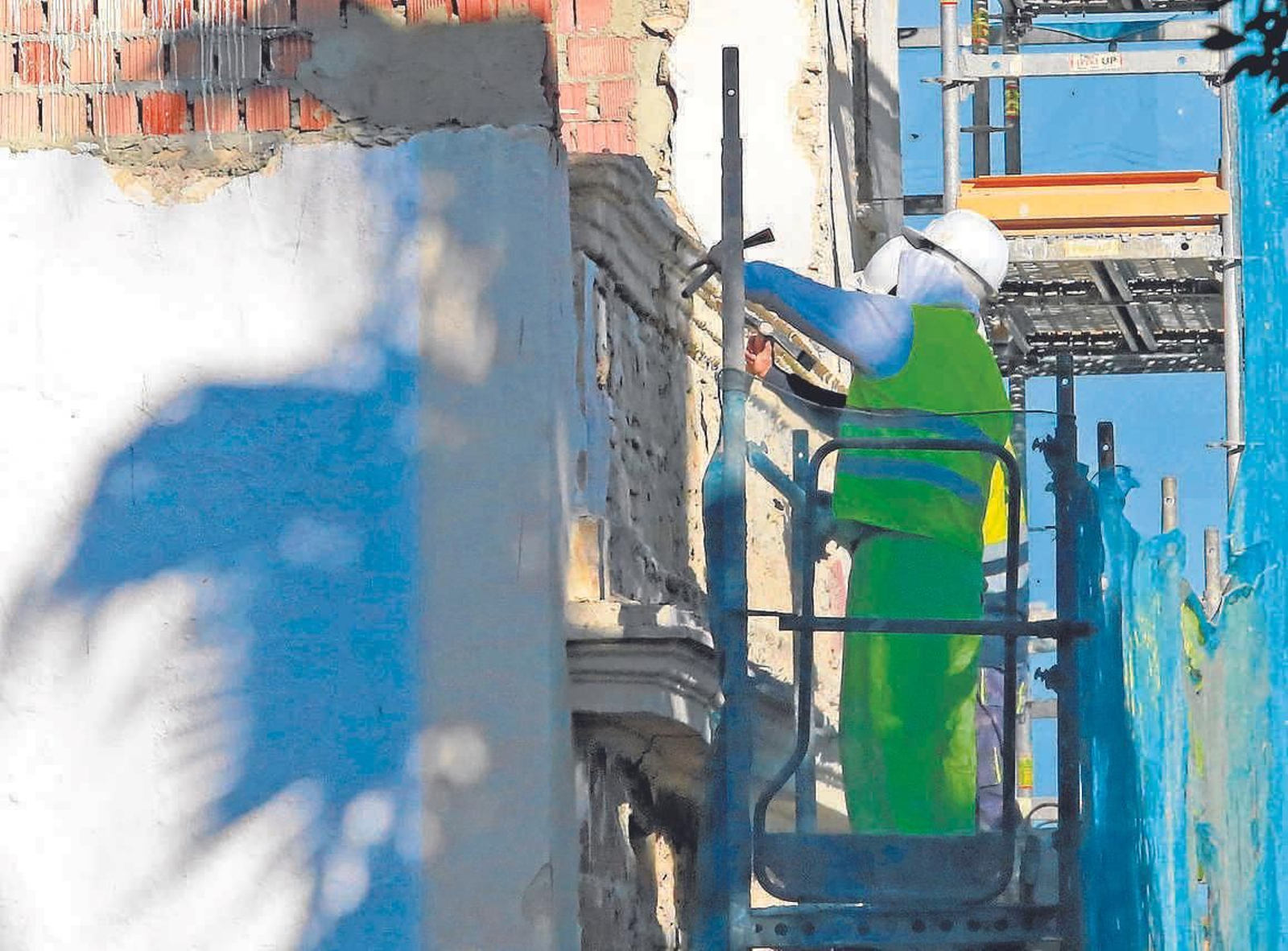 Obreros de la construcción trabajan en las obras de un hotel en el centro.