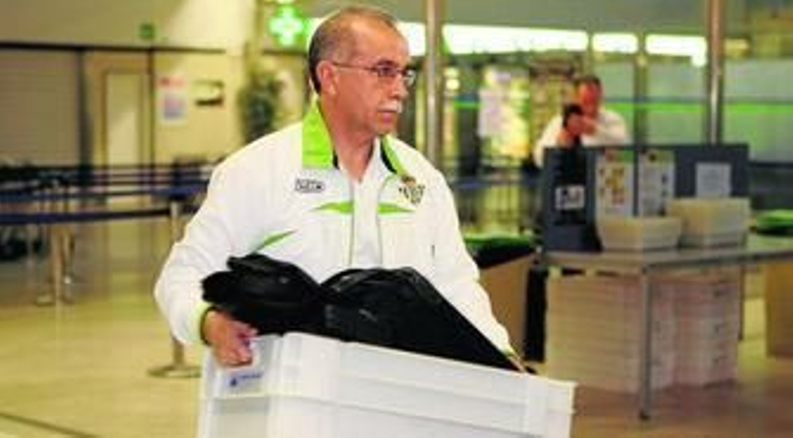 Antonio Tapia carga con su ordenador portátil y otras pertenencias antes de pasar el control de metales en el aeropuerto de San Pablo.