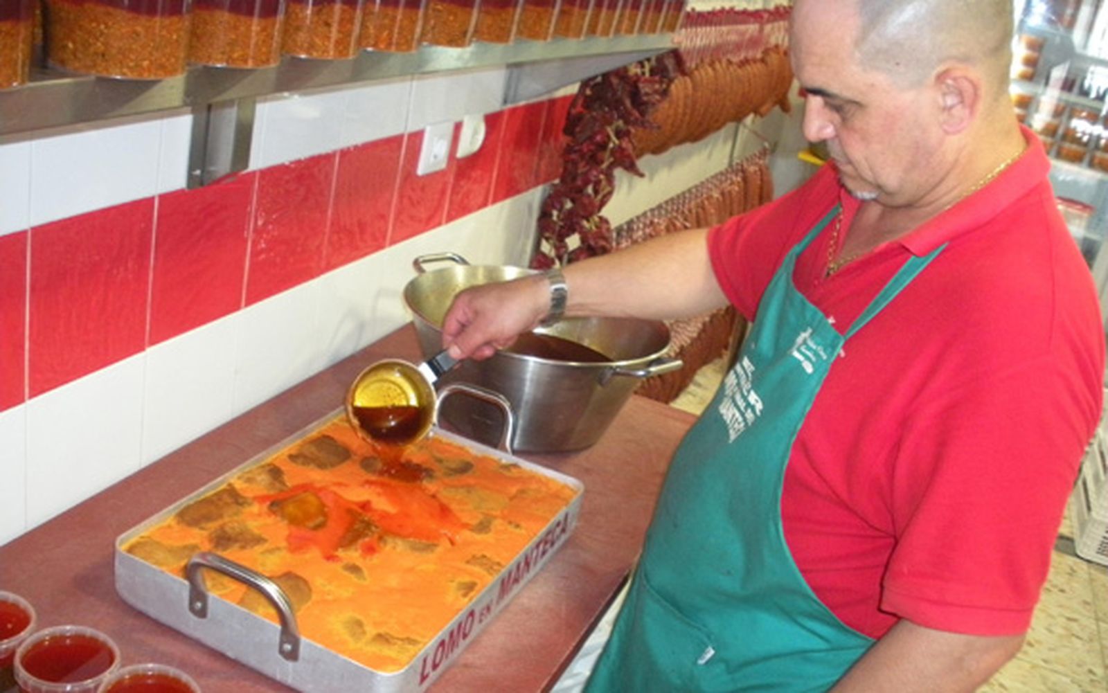 Manuel Melero, de la Carnicería Paco Melero prepara una de las bandejas de lomo en manteca colorá que se podrán degustar este domingo en Vejer. /Manuel Aragón Pina