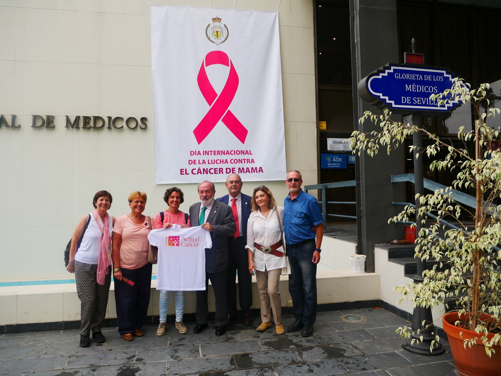 Una gran pancarta con el emblemático lazo rosa que simboliza la lucha contra el cáncer de mama en la fachada principal del Colegio de Médicos.
