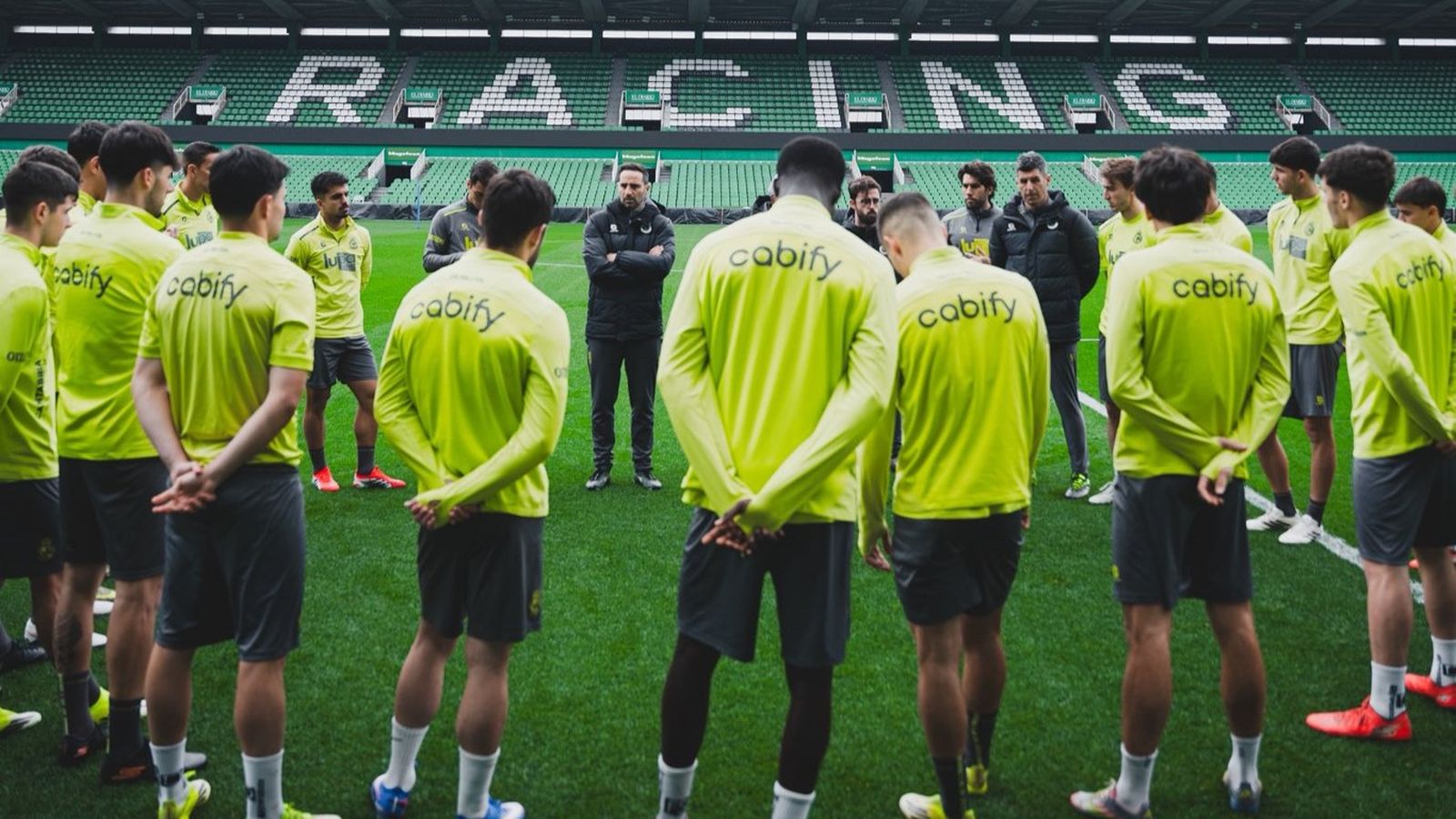 Los jugadores del Racing de Santander escuchan a su cuerpo técnico antes de un entrenamiento.