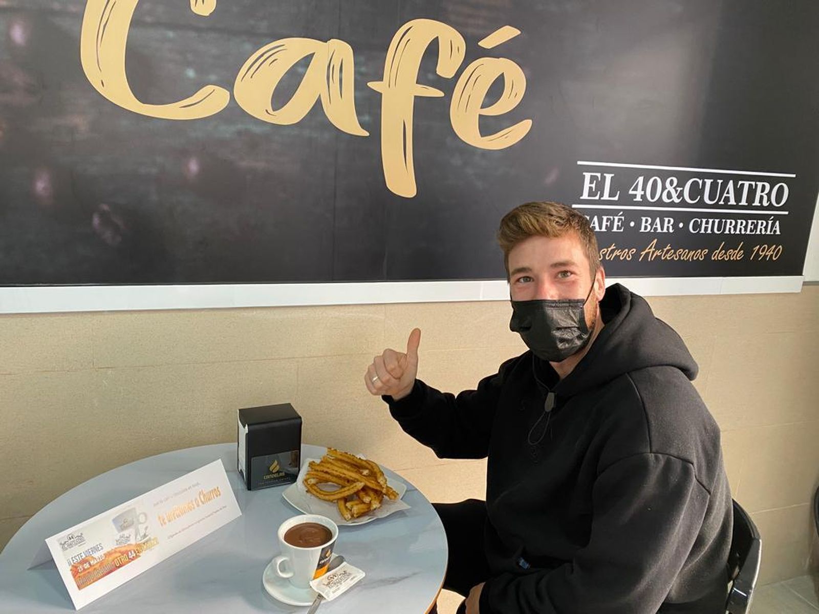 Un cliente posa con un servicio de churros.