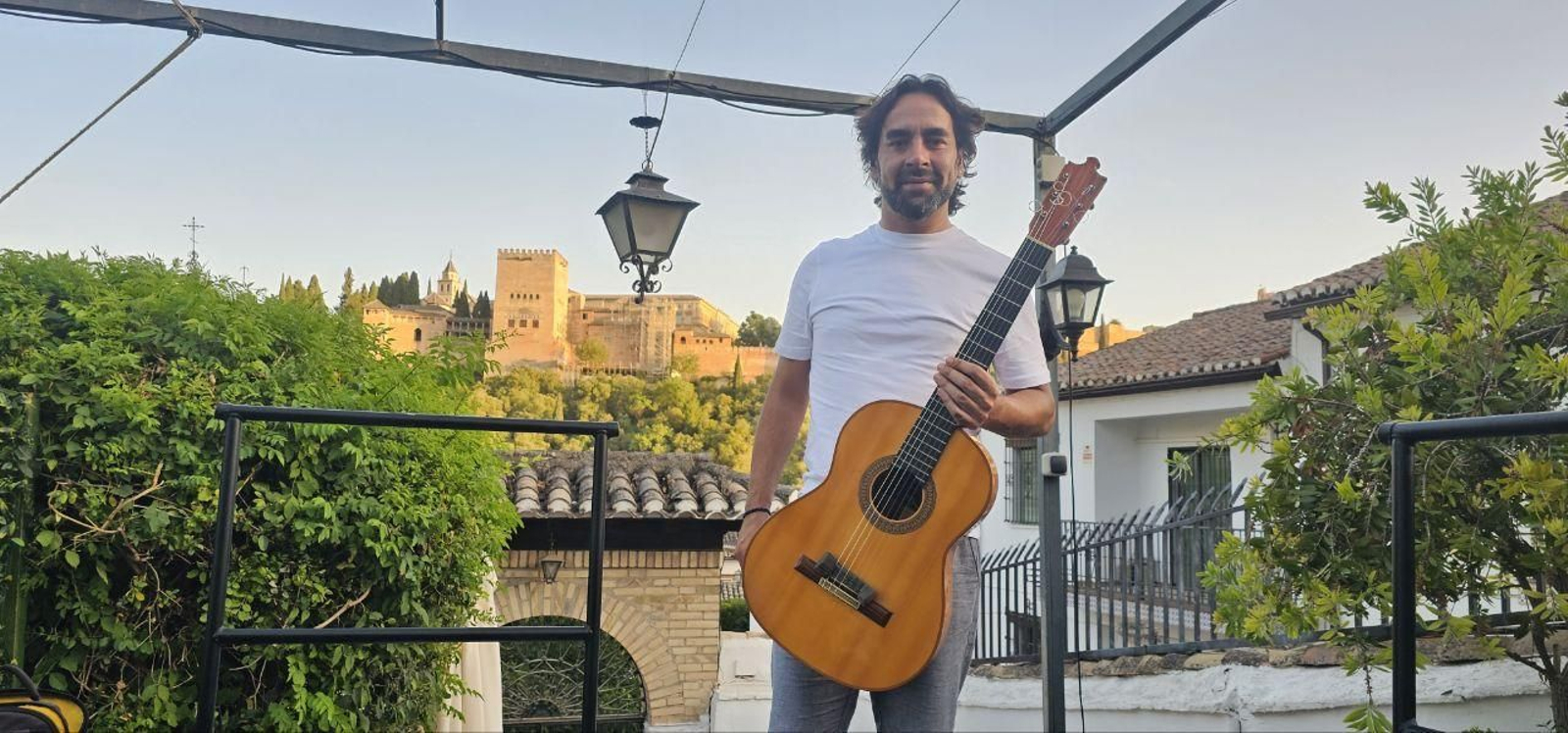 Daniel Casares, junto a su guitarra, posando en el Albaicín y con la Alhambra de fondo
