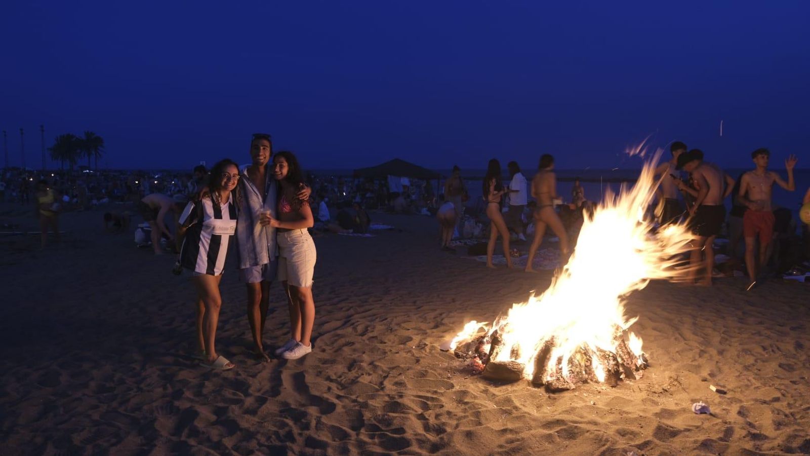 Varios jóvenes junto a una hoguera.