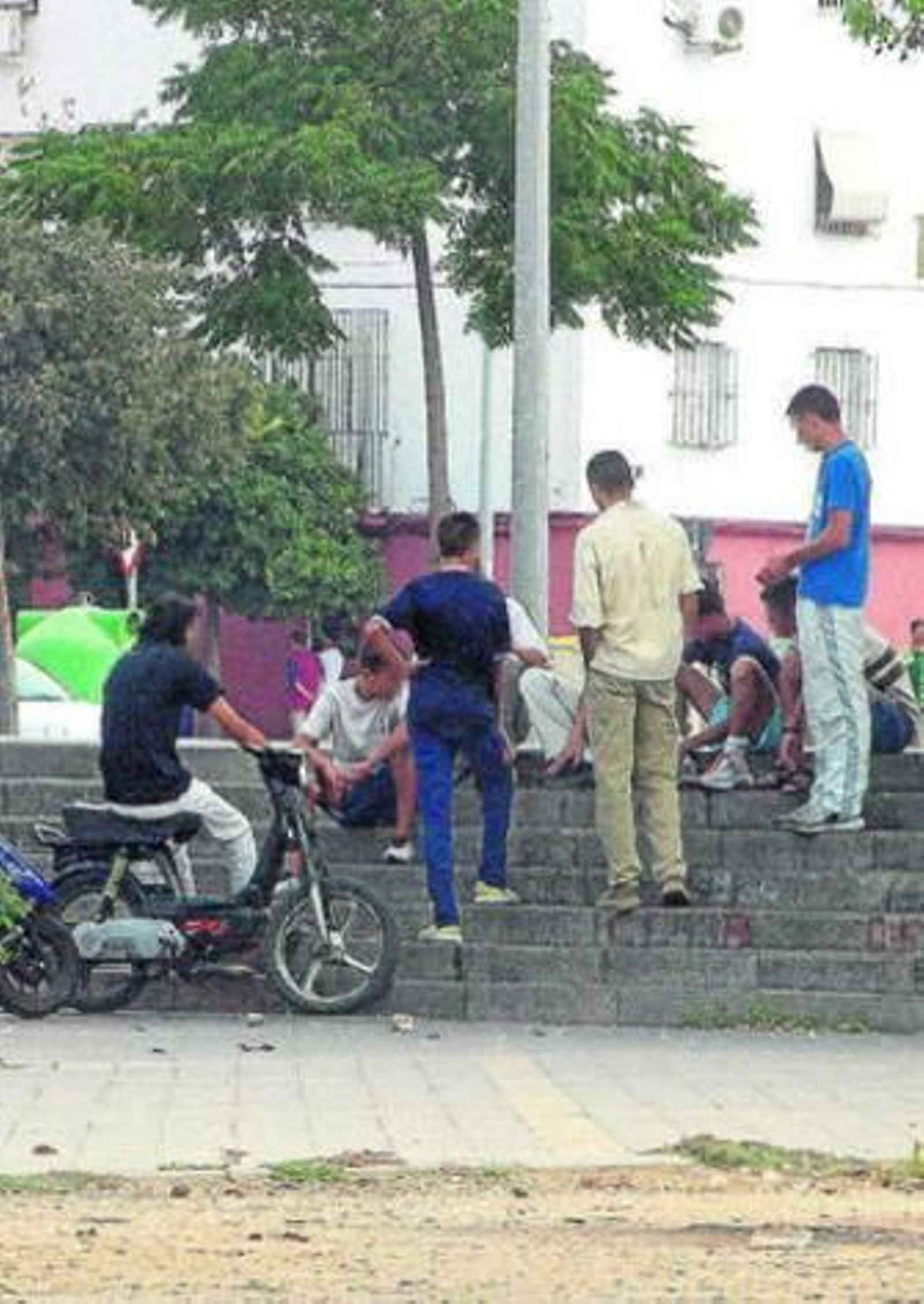 Un grupo de jóvenes conversan en un barrio.