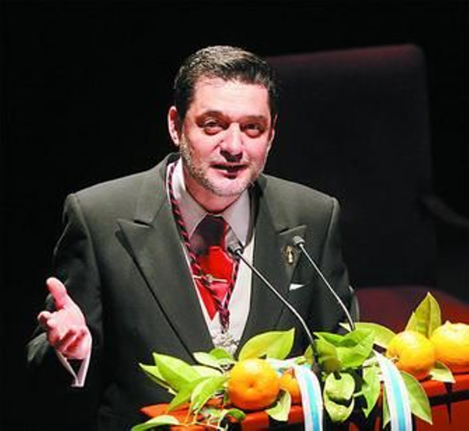 Sugrañes durante su pregón. A la derecha, arriba, el pregonero con José Luis Pons; abajo, su hijo mayor colocándole un pin de un palmito en la solapa.