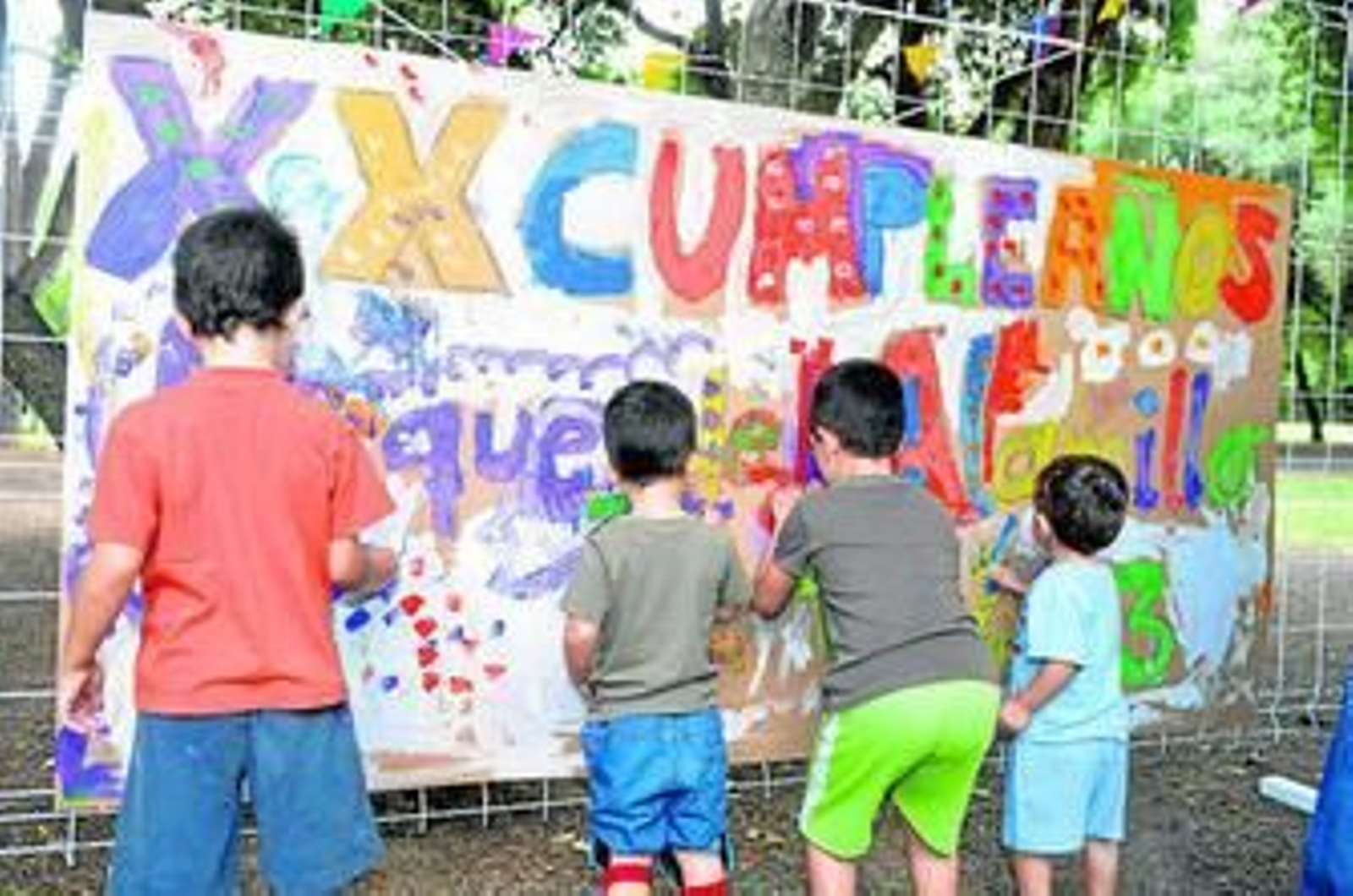 Un grupo de niños pinta un mural de cumpleaños en el Parque del Alamillo.
